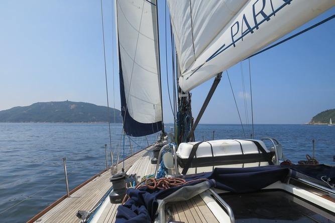 Sailing on a 2003 Nautor Swan 56 R yacht with scenic coastal views.