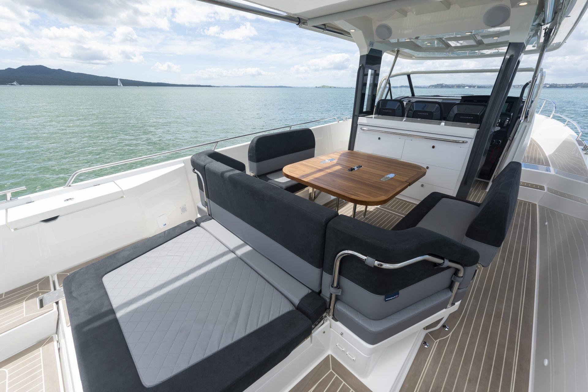 Luxurious 2025 Nimbus Tender 11 yacht interior with seating and table, overlooking serene waters.