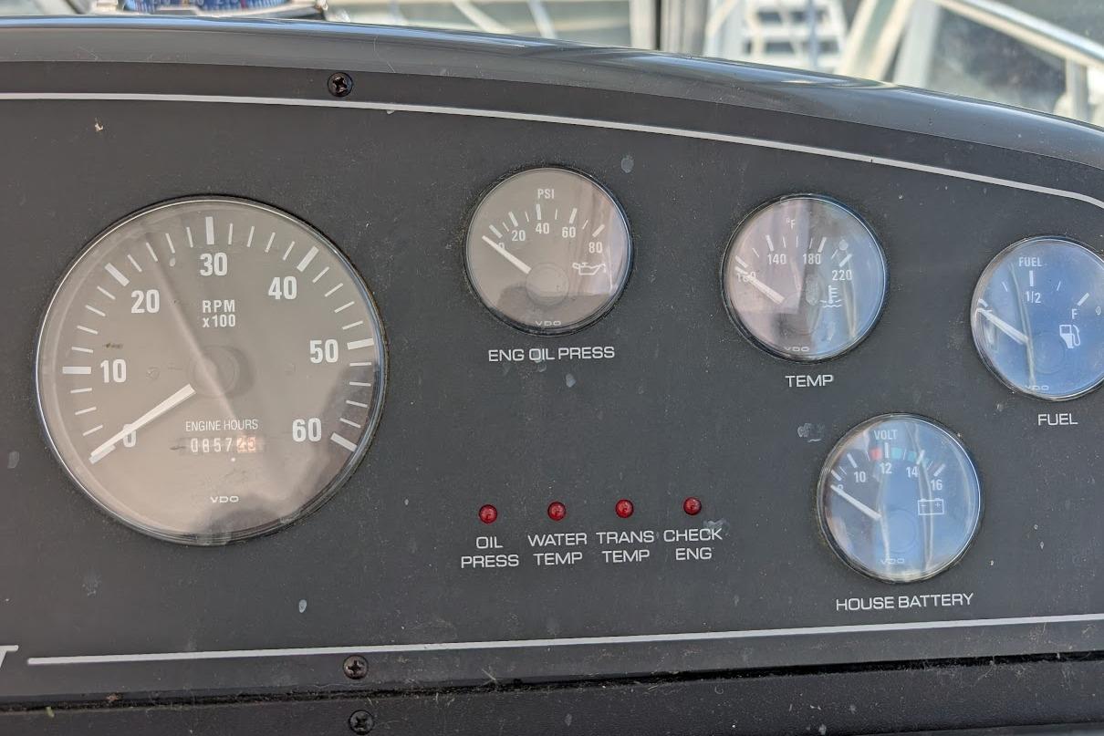 Dashboard of a 2000 Pursuit 3400 Express boat showing RPM, oil, temperature, and fuel gauges.