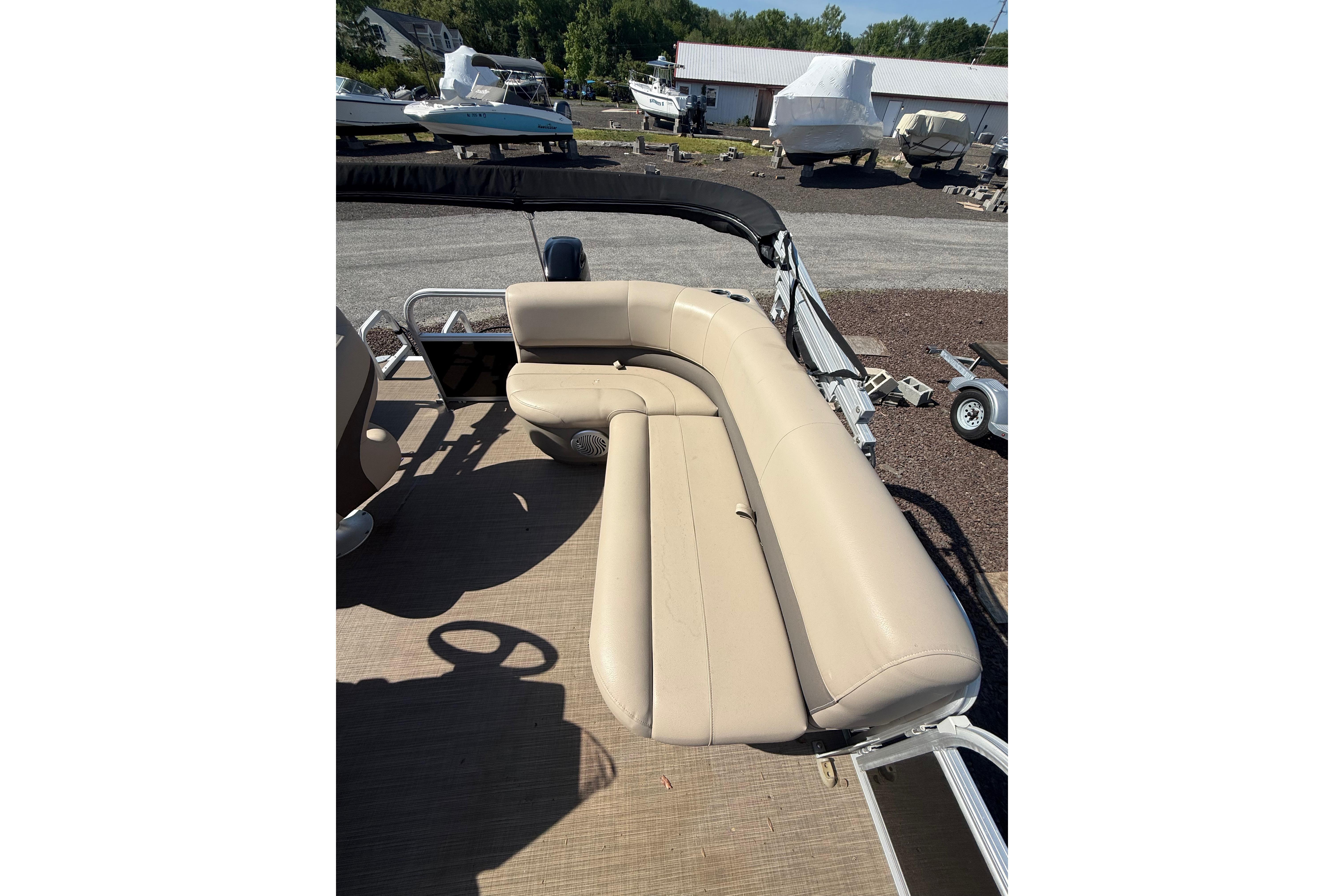 2021 Sun Tracker Bass Buggy 16 XL Select pontoon boat with beige seating.
