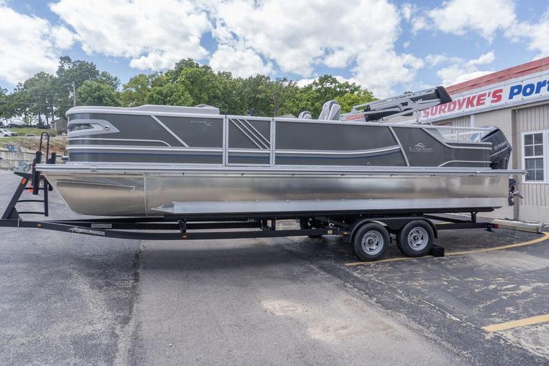 2026 SunCatcher Elite 326 SL pontoon boat on trailer, parked outside dealership.