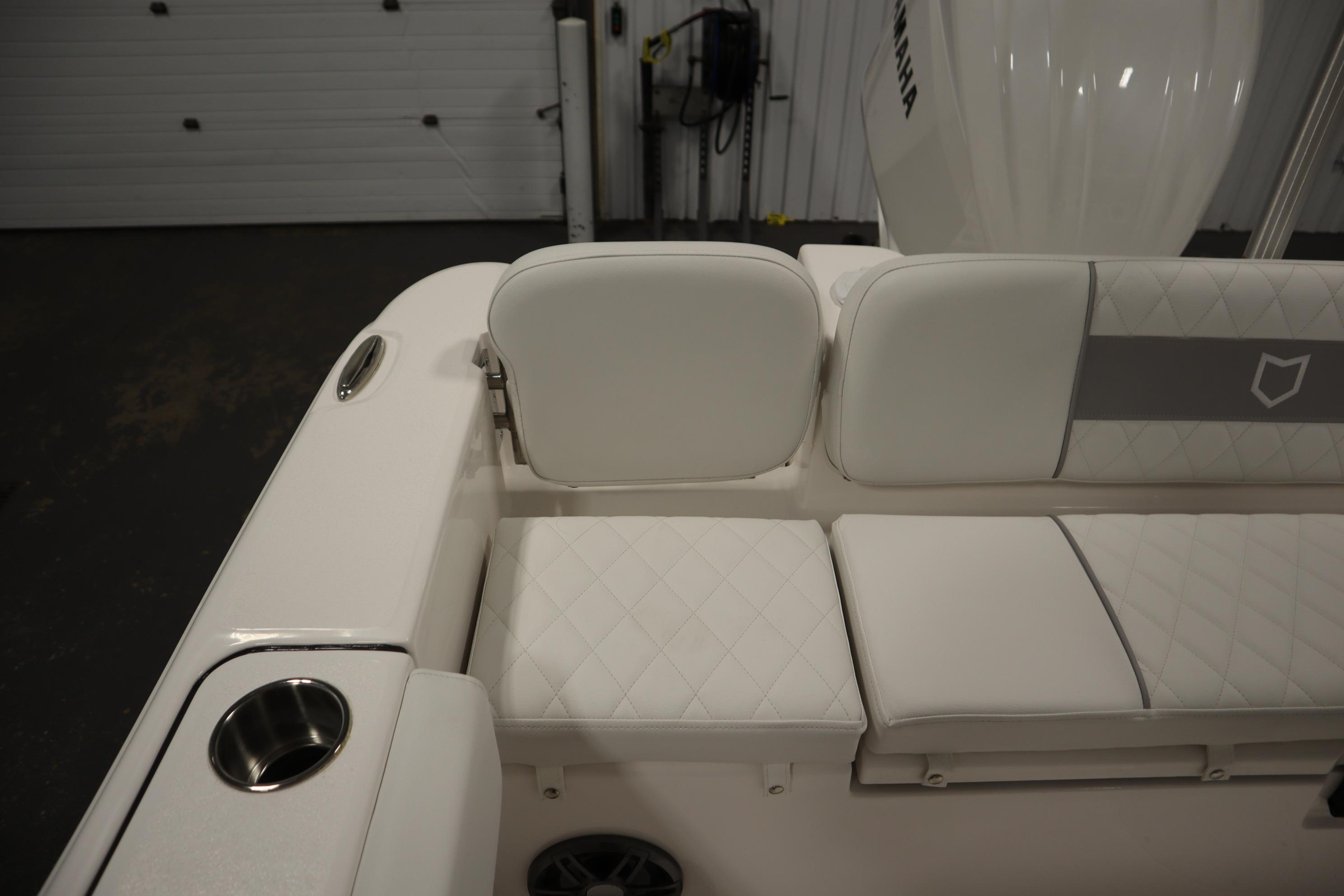 2026 Sea Fox 228 Commander boat interior with cushioned seating and cup holder.