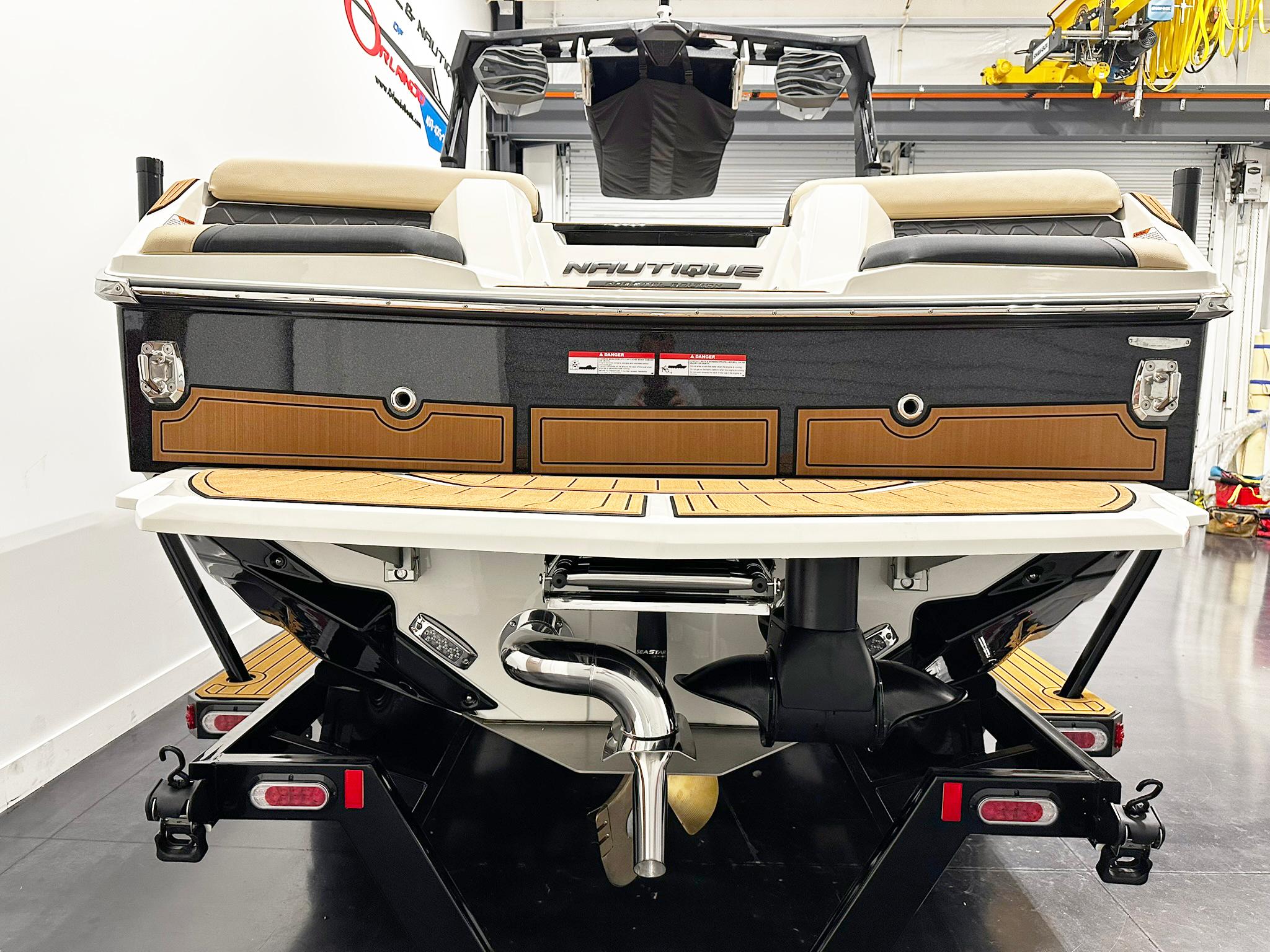 2026 Nautique GS24 boat rear view in a showroom, showcasing sleek design and modern features.