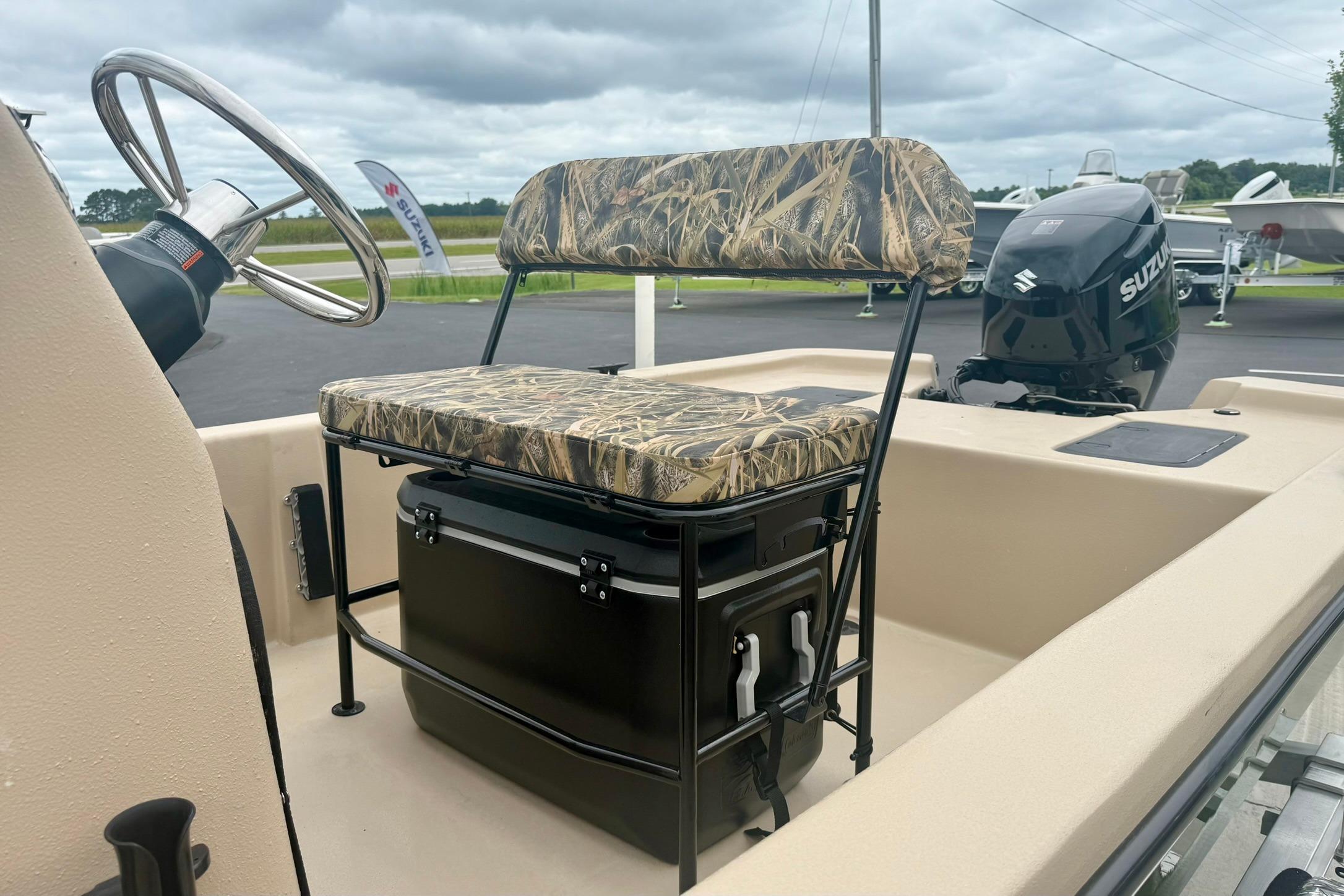 2026 Carolina Skiff E18 JVX CC boat interior with camo seat and Suzuki outboard motor.