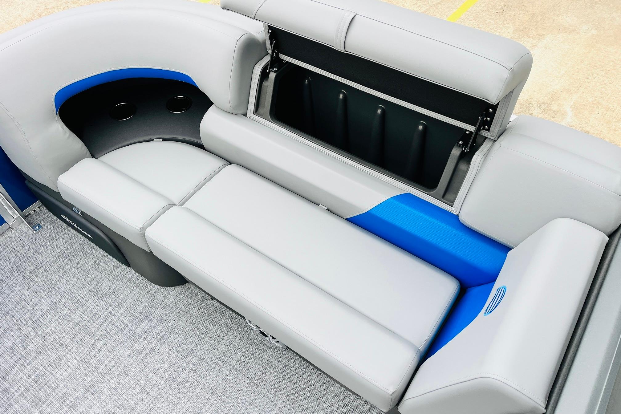 2026 Sun Tracker Party Barge 22 RF DLX interior seating with storage compartment.