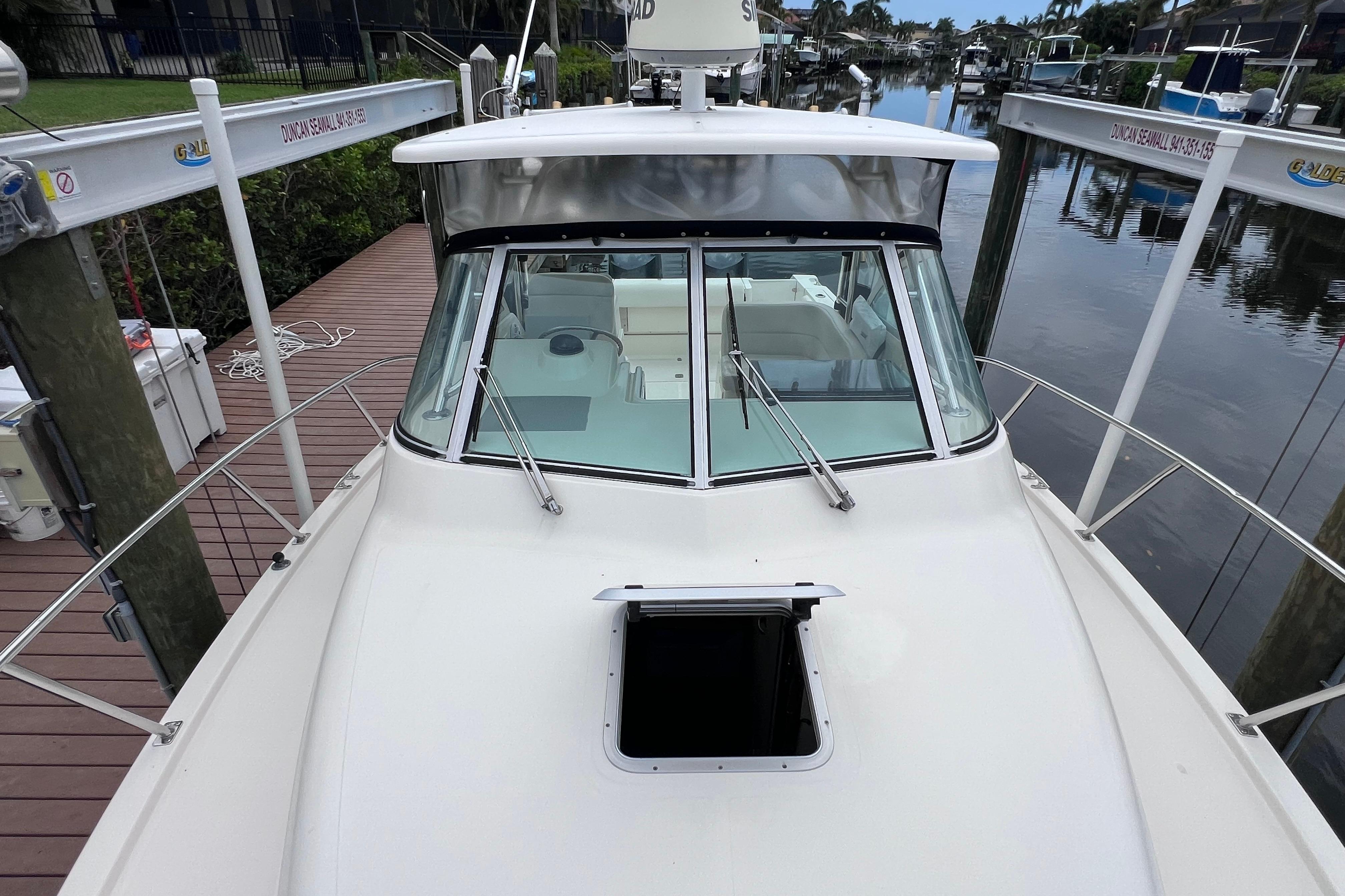 2005 Pursuit 3070 Offshore boat docked, showcasing sleek design and spacious deck.