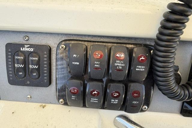 Control panel of a 2006 Sailfish 2660 CC boat with labeled switches and Lenco trim tab controls.