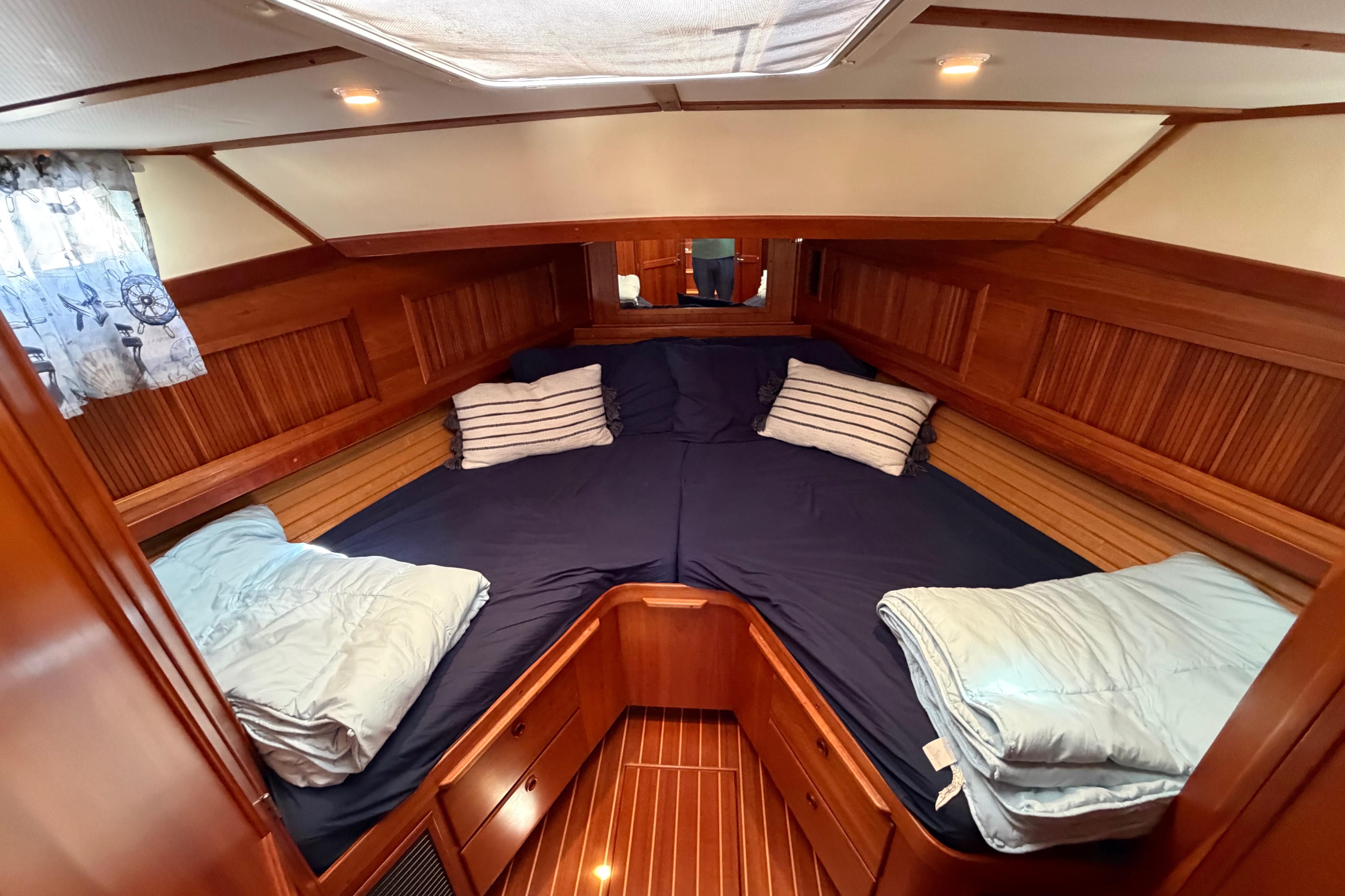 Cozy cabin interior of 2000 Sabreline 36 Express with wood paneling and blue bedding.