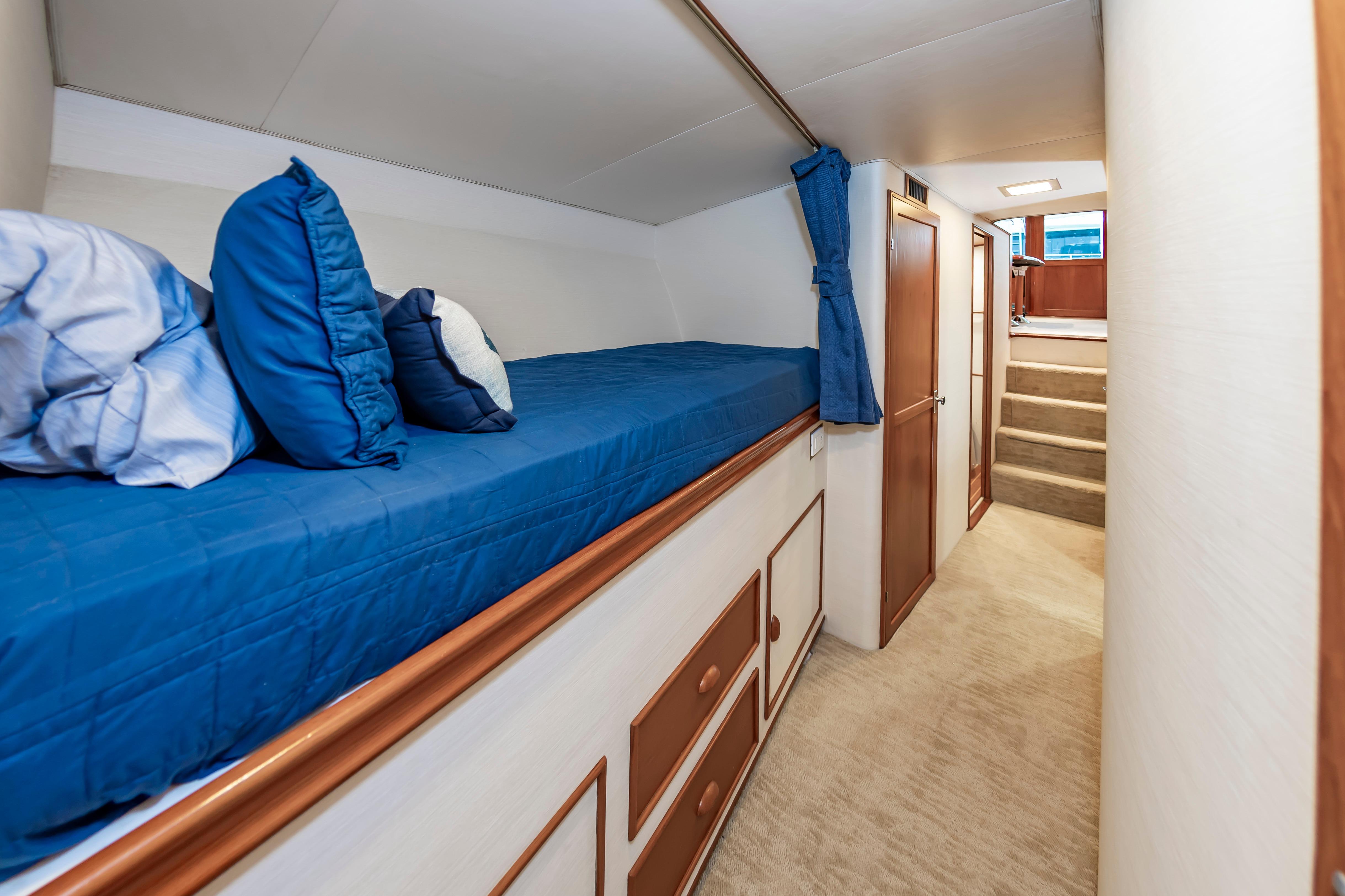 Interior of 1993 Custom Carolina Scarborough 56 Convertible with blue bedding and wooden accents.