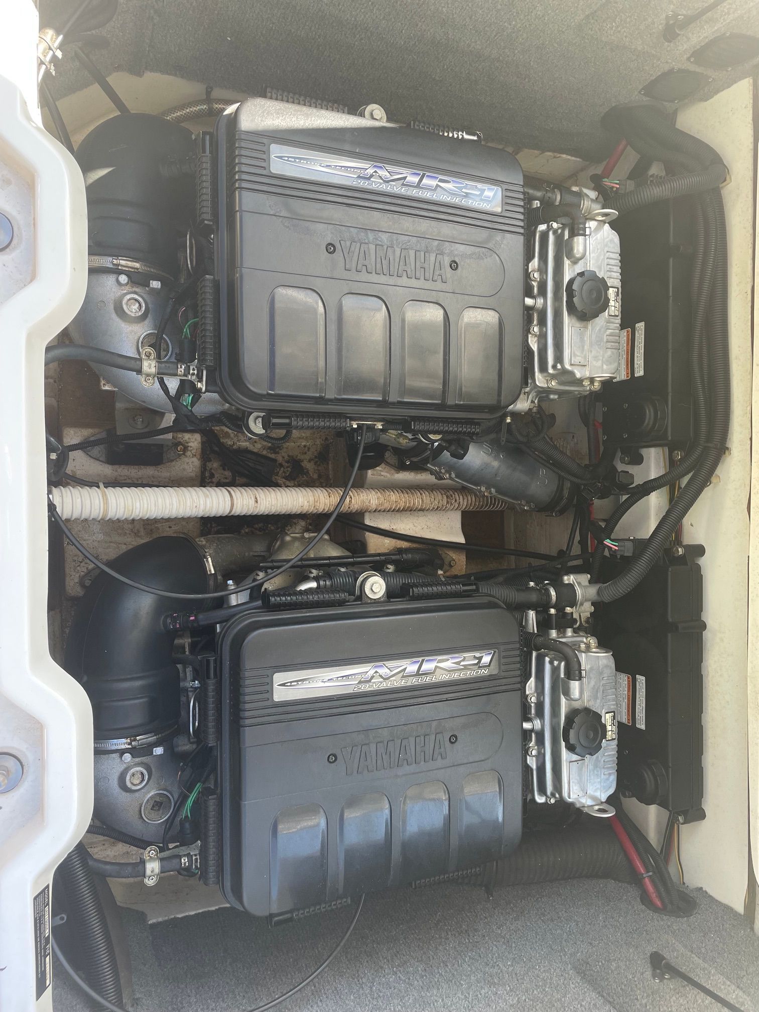 Two Yamaha engines in a boat's engine compartment, neatly installed with visible hoses and cables.
