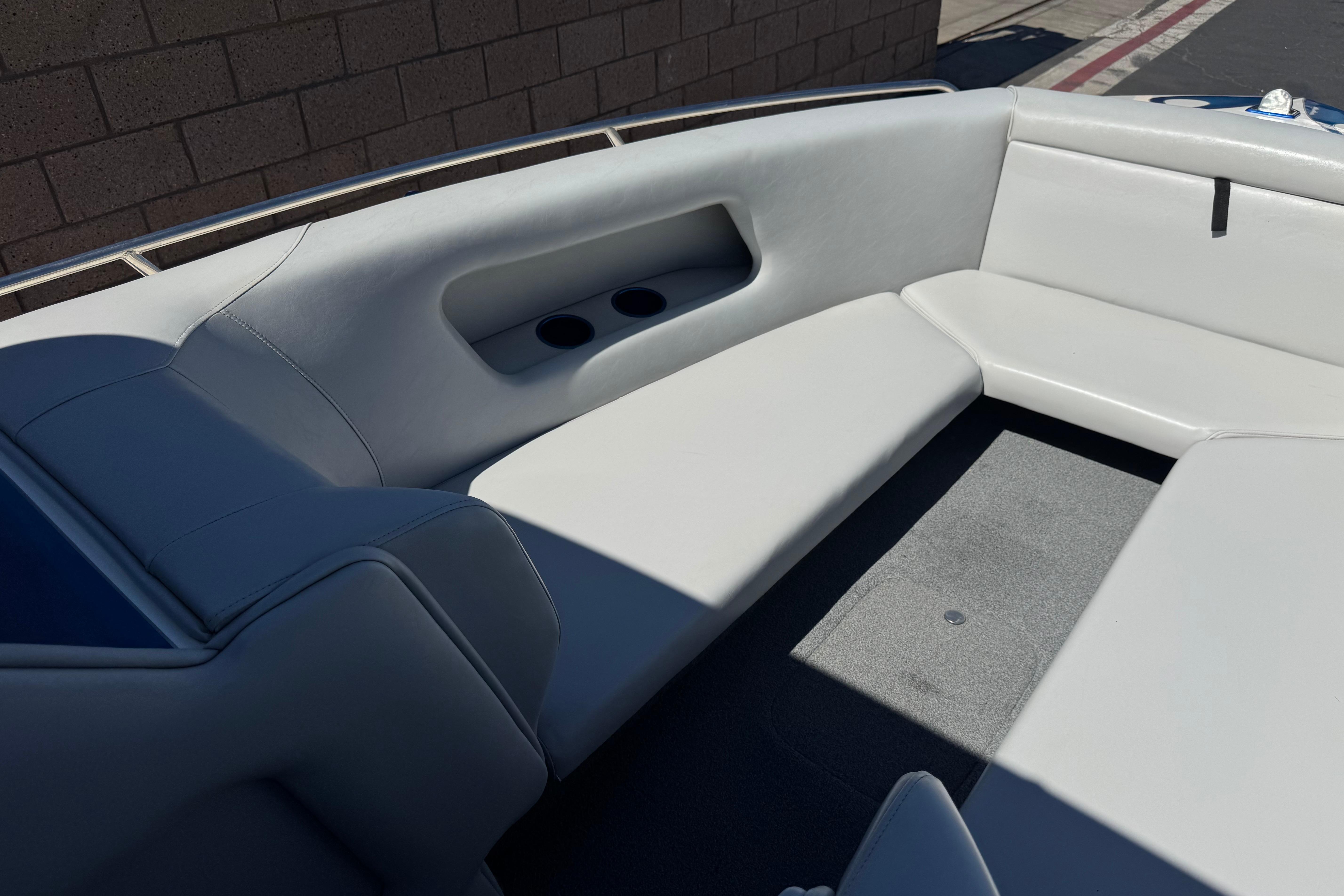 Interior seating of a 2007 Commander 2300LX boat, featuring white upholstery and cup holders.