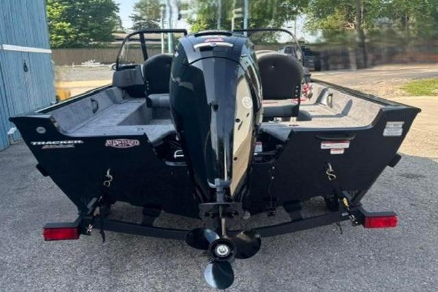 2026 Tracker Pro Guide V-16 WT boat with outboard motor, parked outdoors.