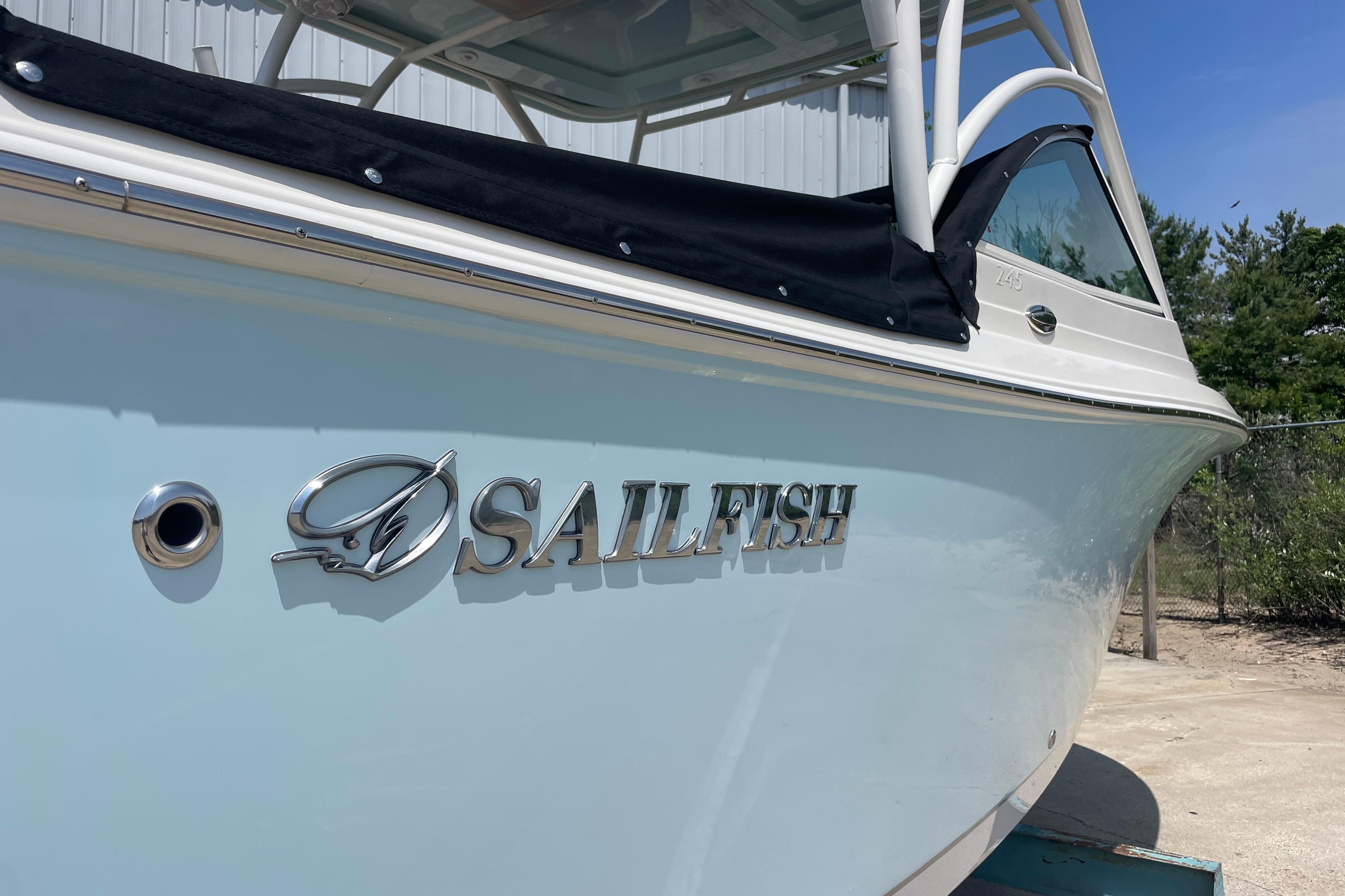 2022 Sailfish 245 DC boat with logo, docked outdoors on a sunny day.