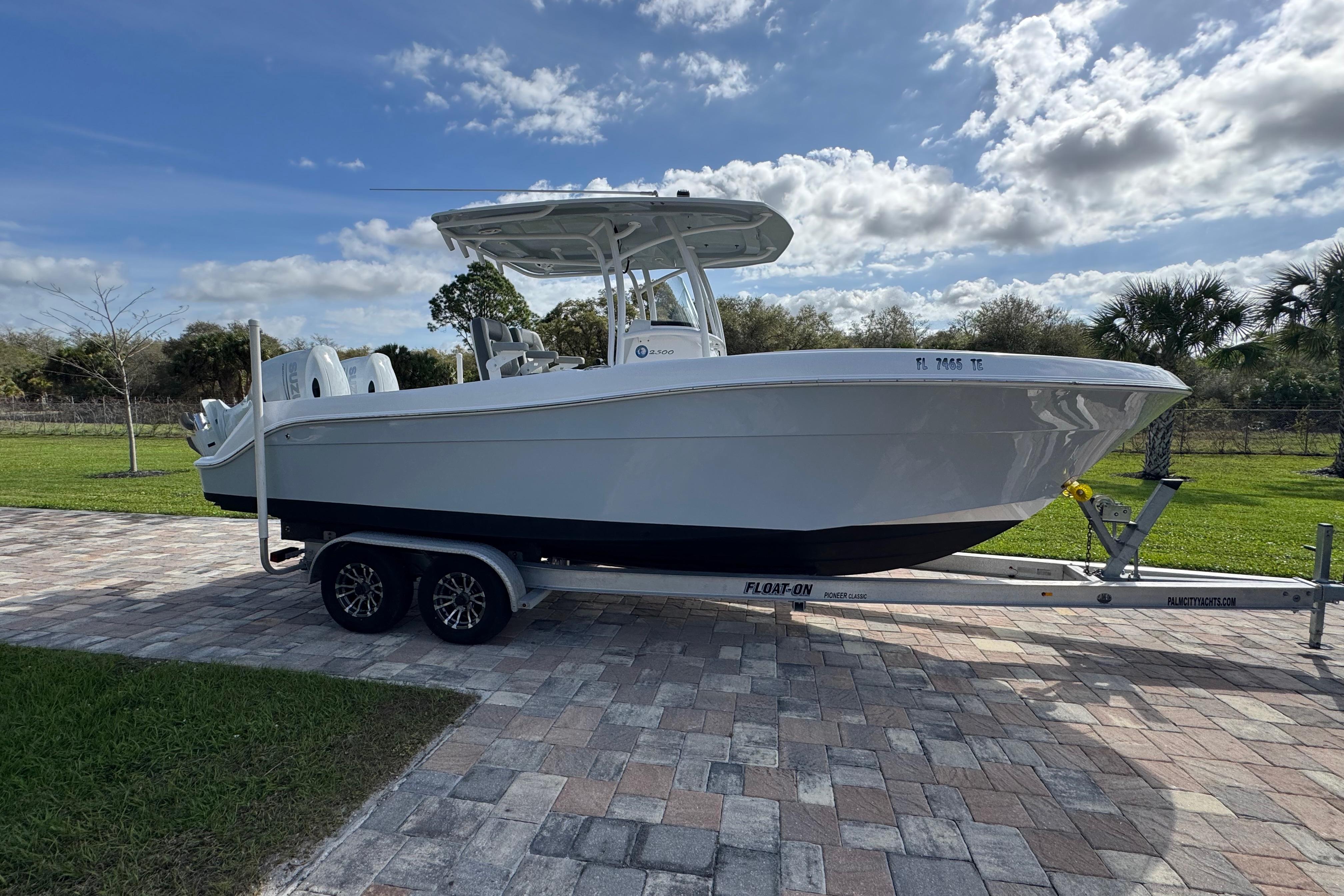 2022 Aquasport 2500 Center Console boat on trailer, parked on paved driveway.