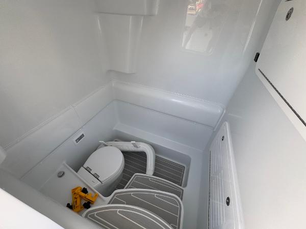 2025 Yellowfin 39 Offshore boat interior with compact marine toilet and storage.