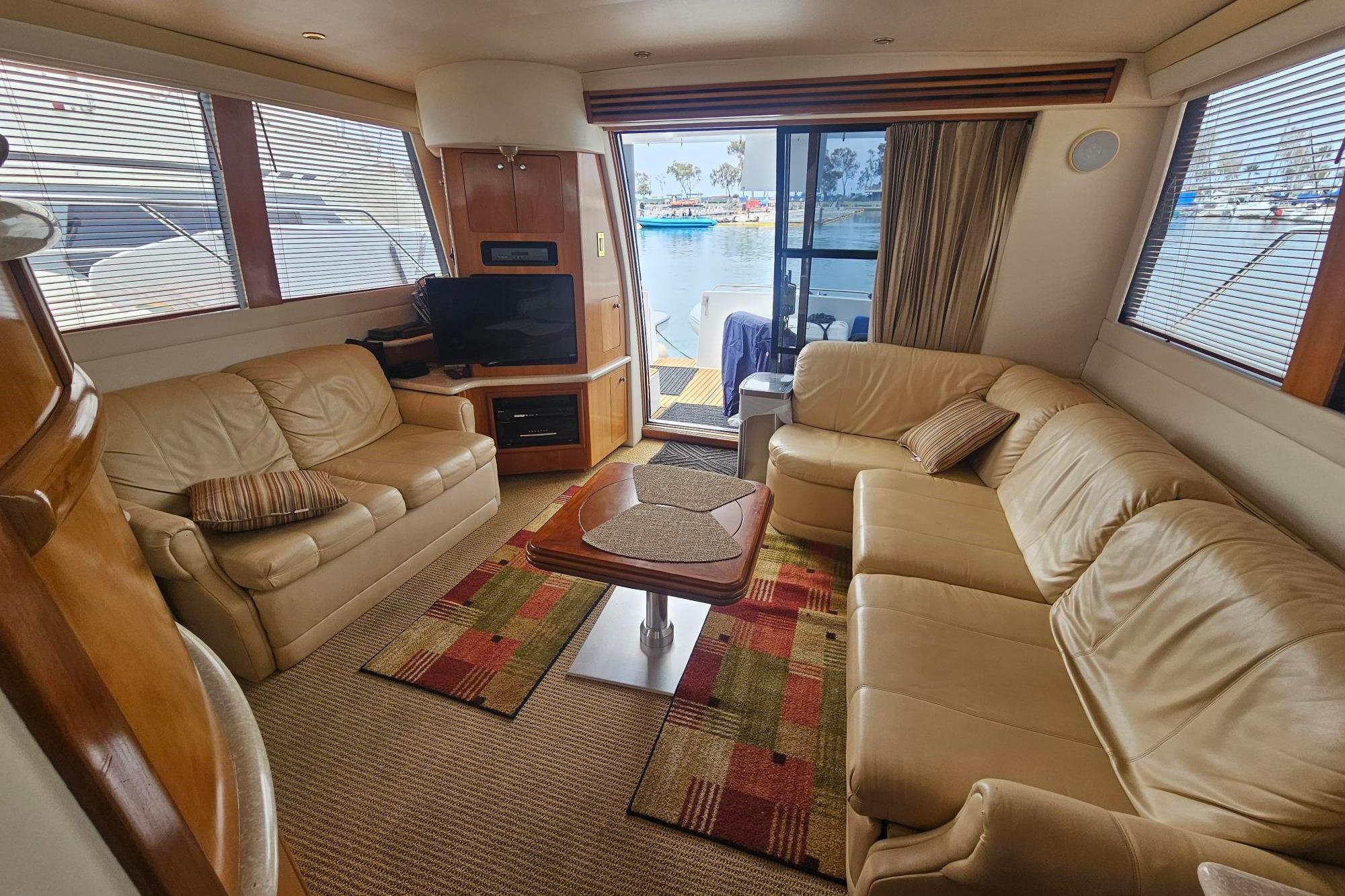 Luxurious interior of 2002 Carver 450 Voyager Pilothouse with leather seating and waterfront view.