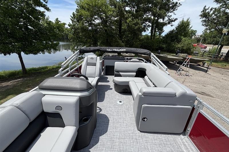 2026 Sun Tracker SportFish 20 DLX pontoon boat with spacious seating and scenic lake view.