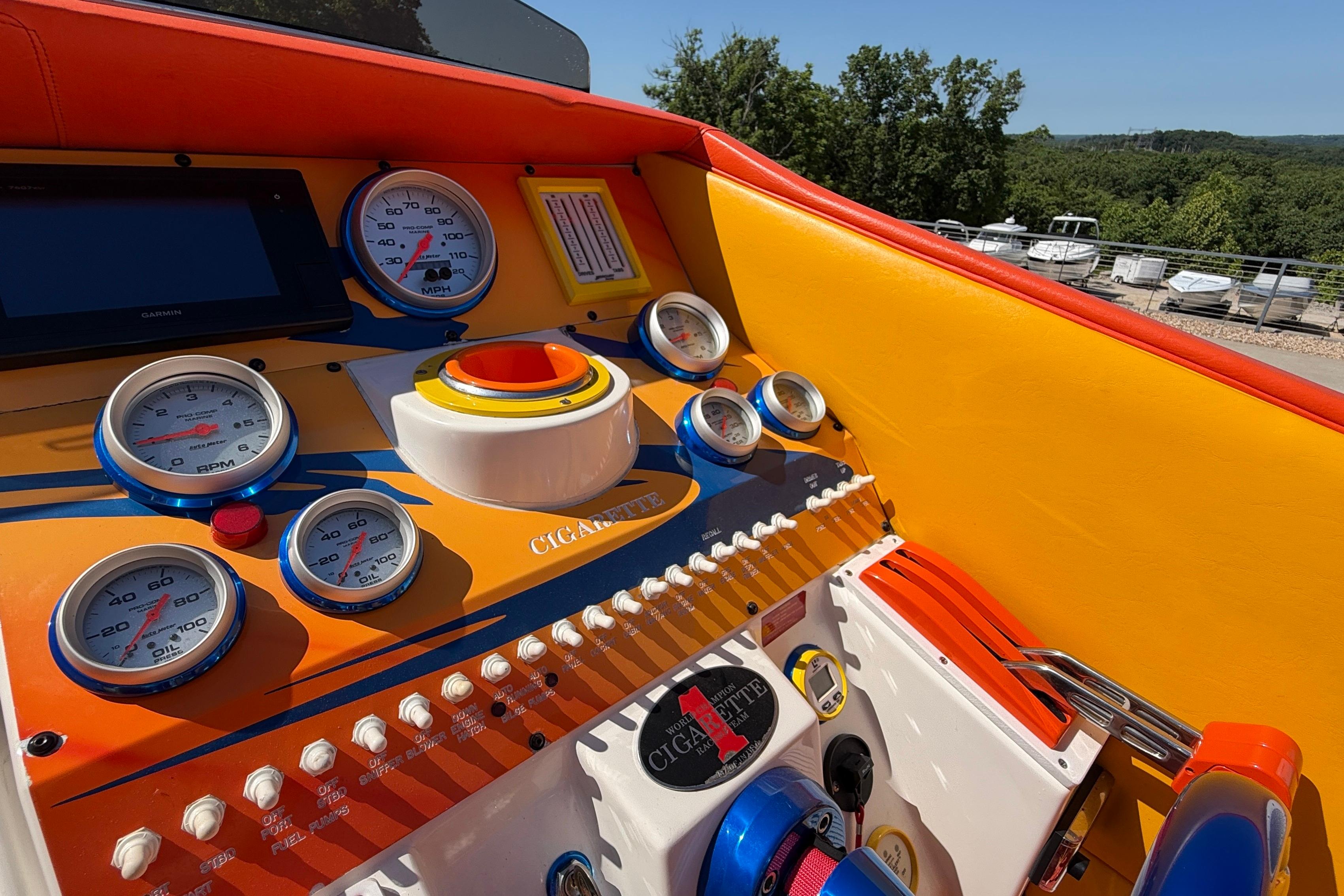 2002 Cigarette 35' Cafe Racer dashboard with vibrant orange and yellow design, featuring multiple gauges.