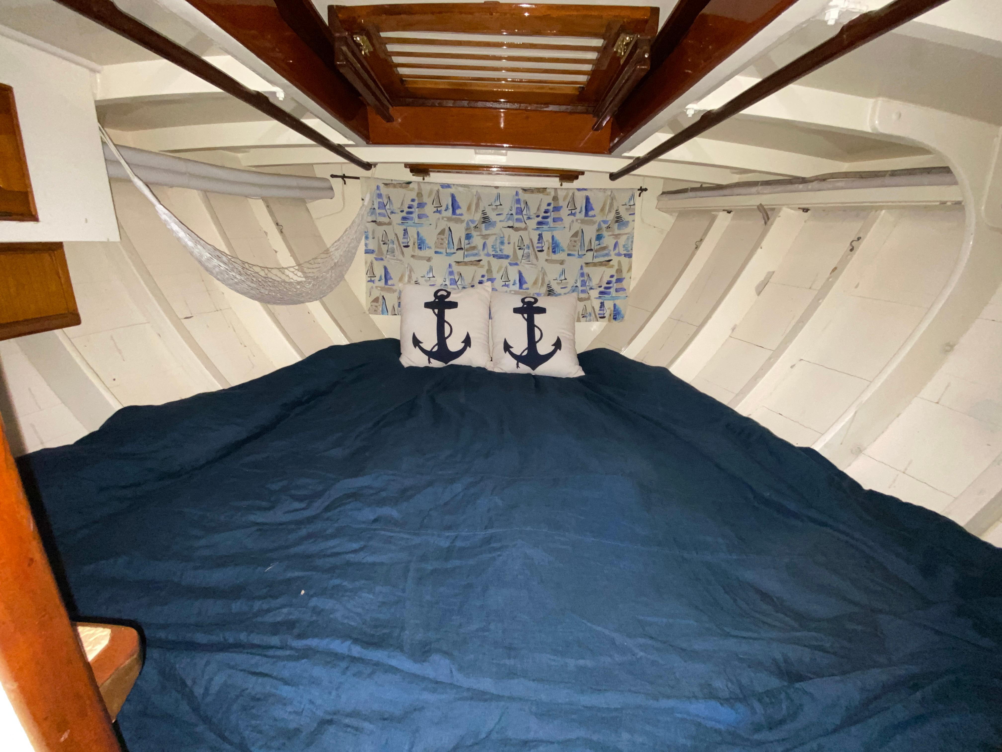 Cozy 1962 Cheoy Lee Custom boat cabin with nautical decor and blue bedding.