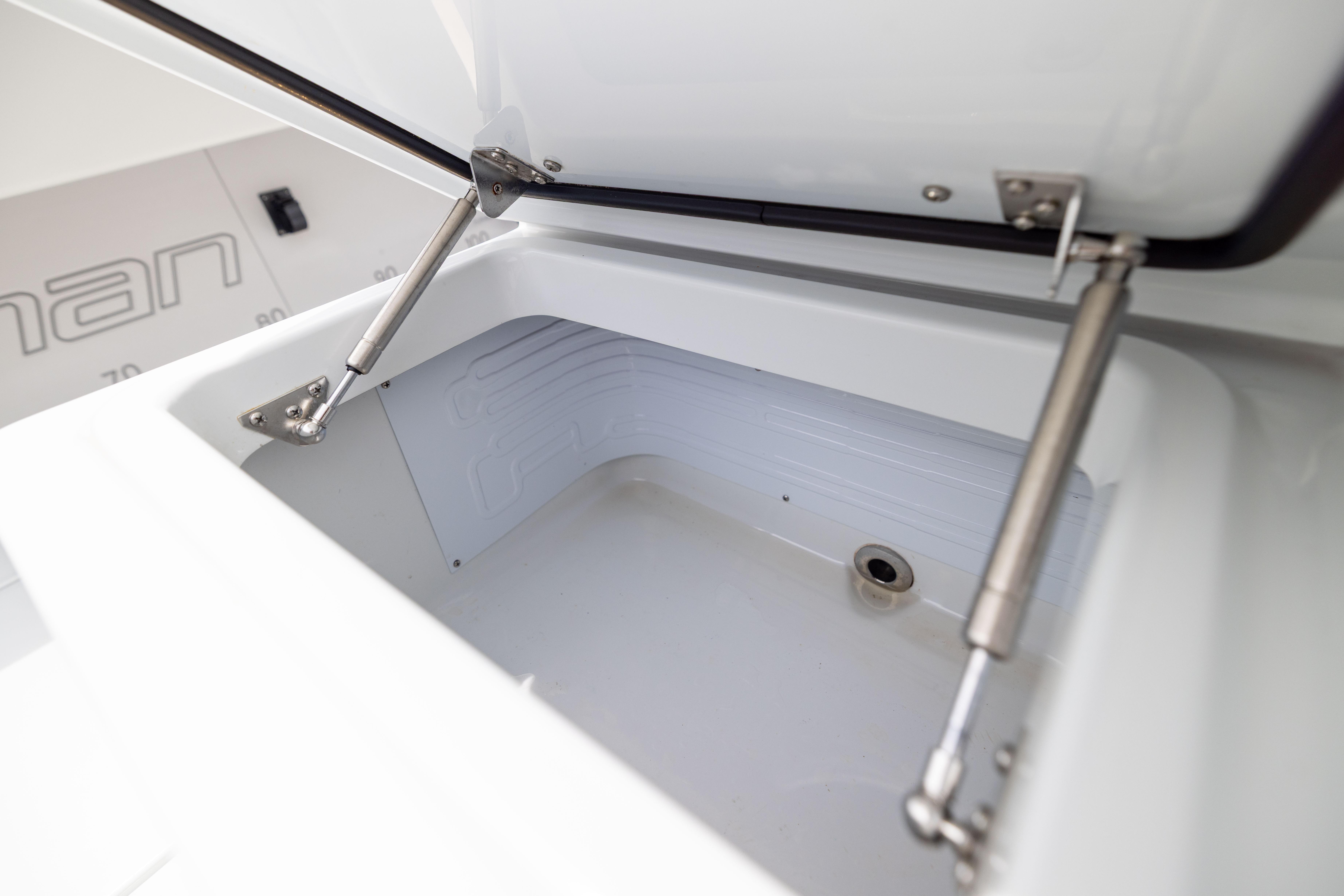 Open storage compartment on 2025 Freeman 42 LR boat, showcasing hydraulic hinges.