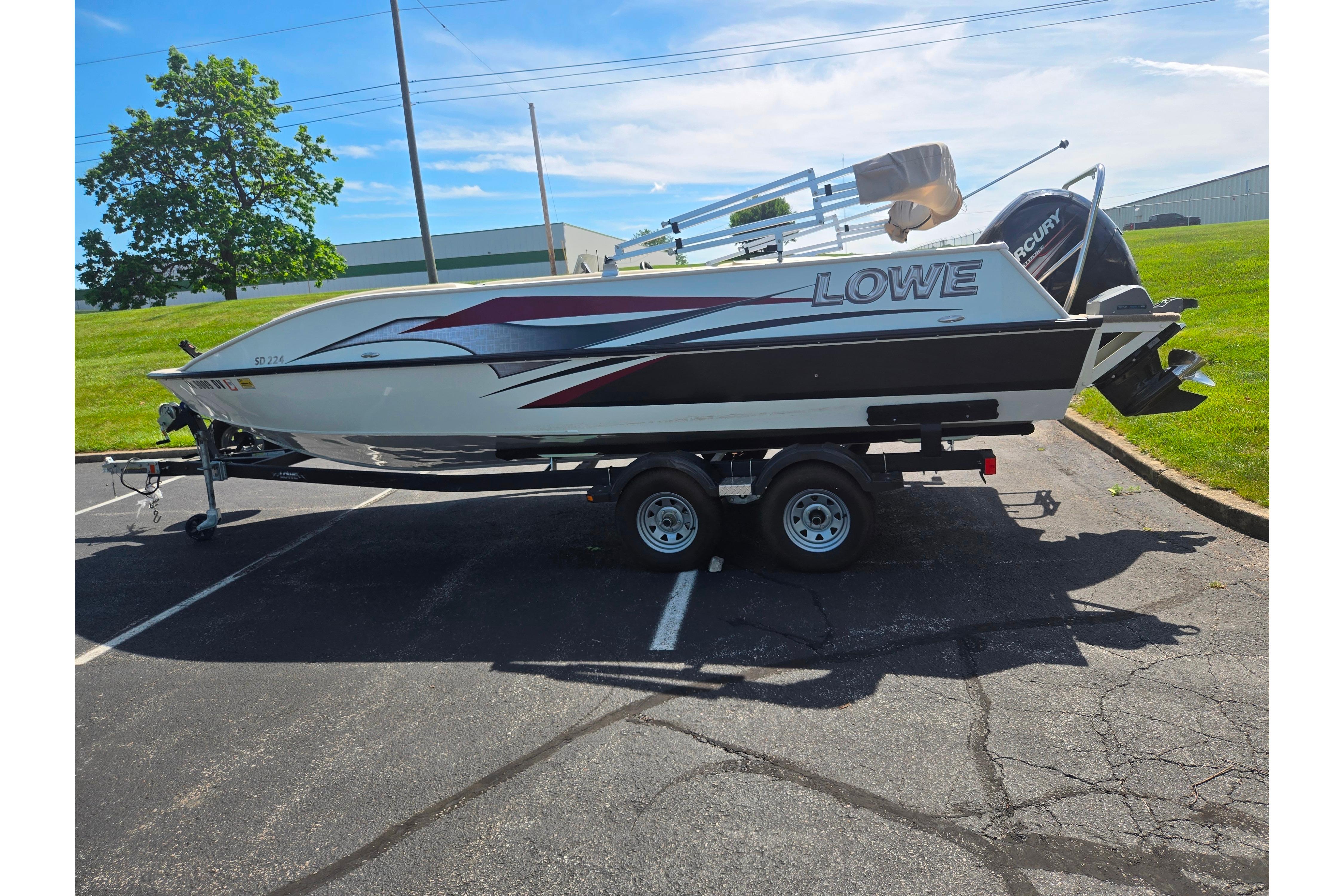 2015 Lowe Sport Deck 224 boat on trailer in parking lot, sunny day.