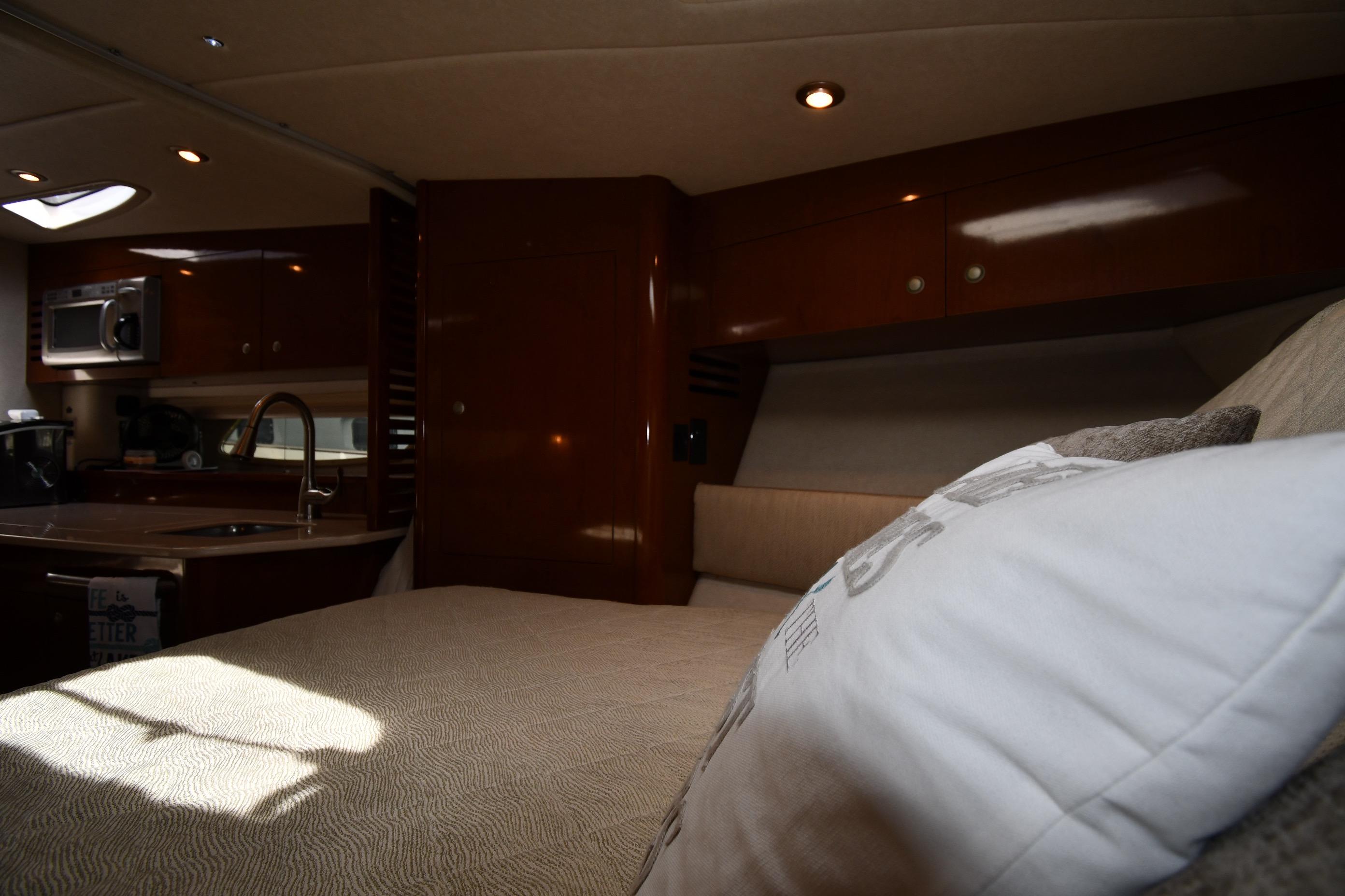 Interior of 2008 Sea Ray Sundancer 350 yacht with cozy bed and kitchenette.