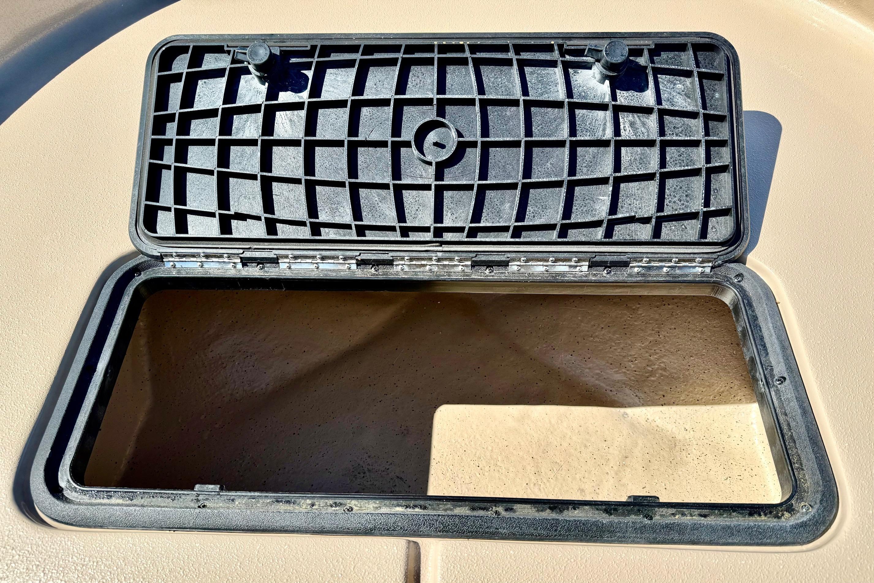 Open storage compartment on 2026 Carolina Skiff E18 JVX CC boat.