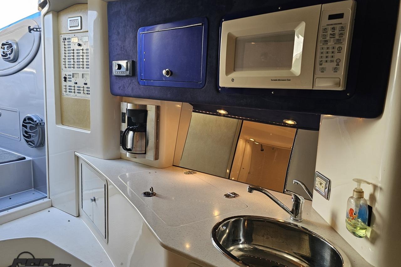 2007 Hustler 41 Razor boat interior with kitchenette, featuring microwave, coffee maker, and sink.