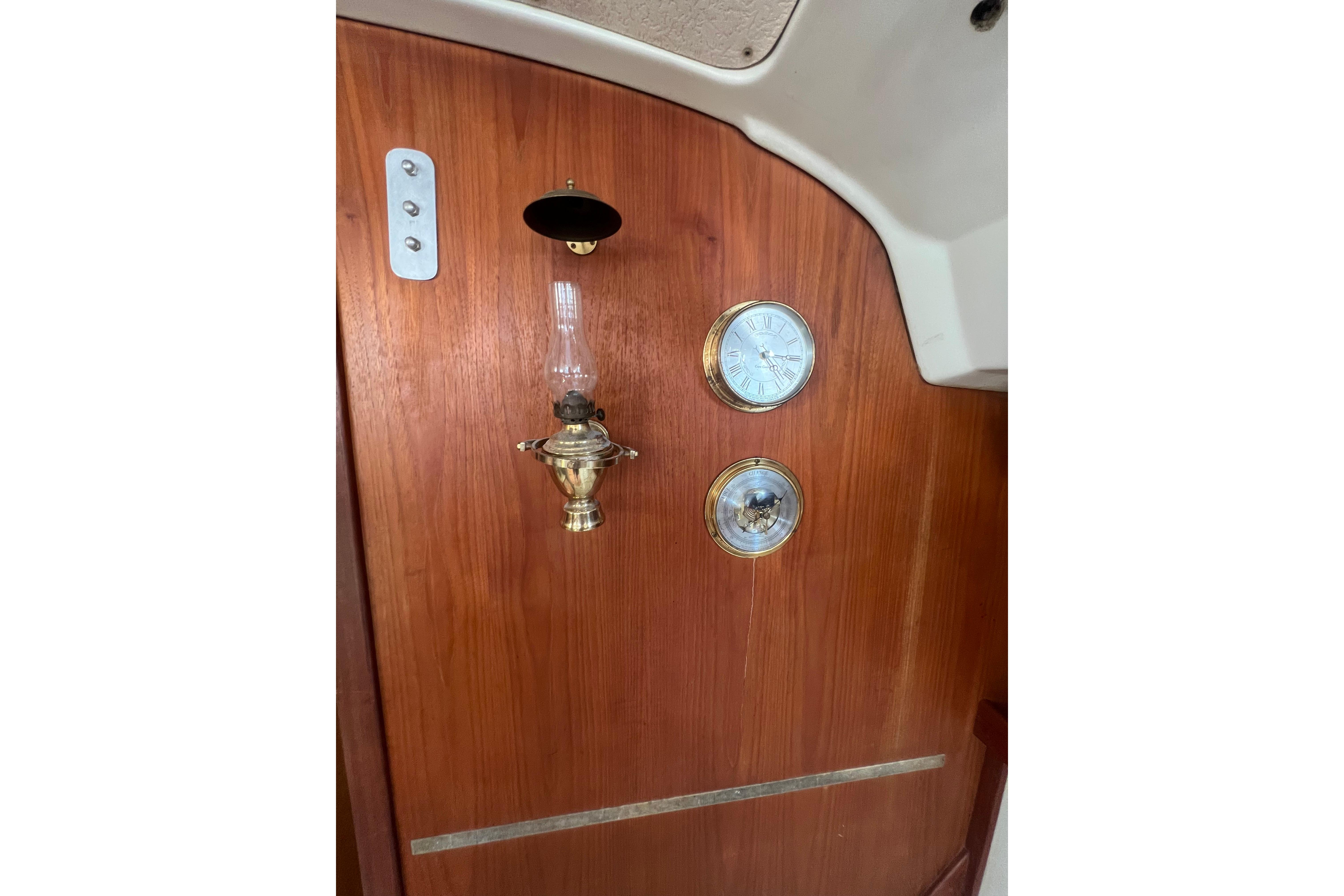 Wooden interior of 1981 C&C 34 yacht with brass lamp and clock.
