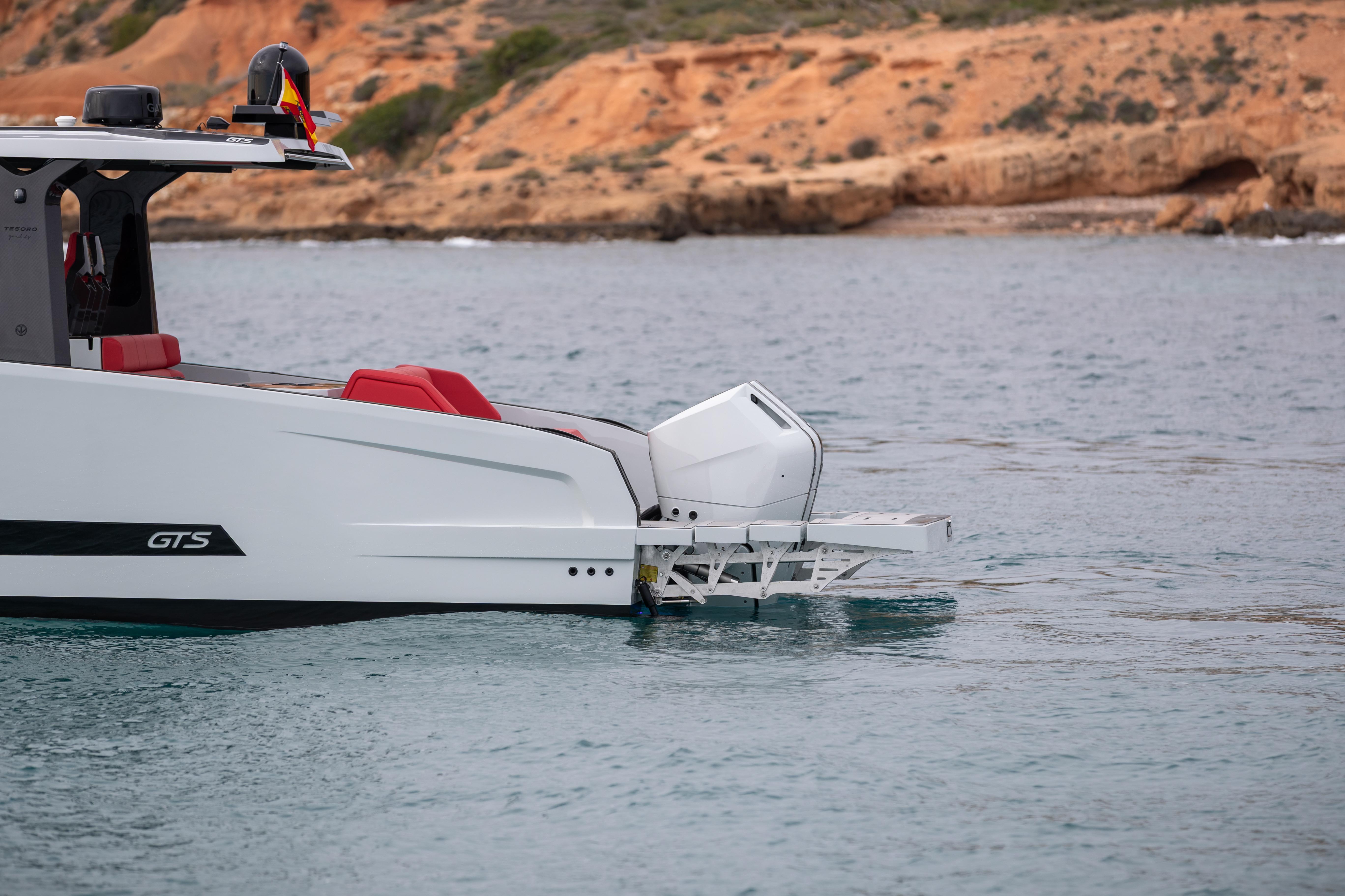 Tesoro 40 GTS 2026 yacht on calm water near rocky coastline.