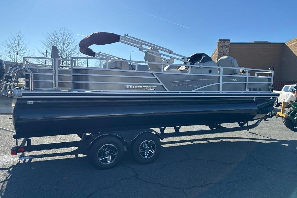 2024 Ranger Reata 220F pontoon boat on trailer in parking lot.