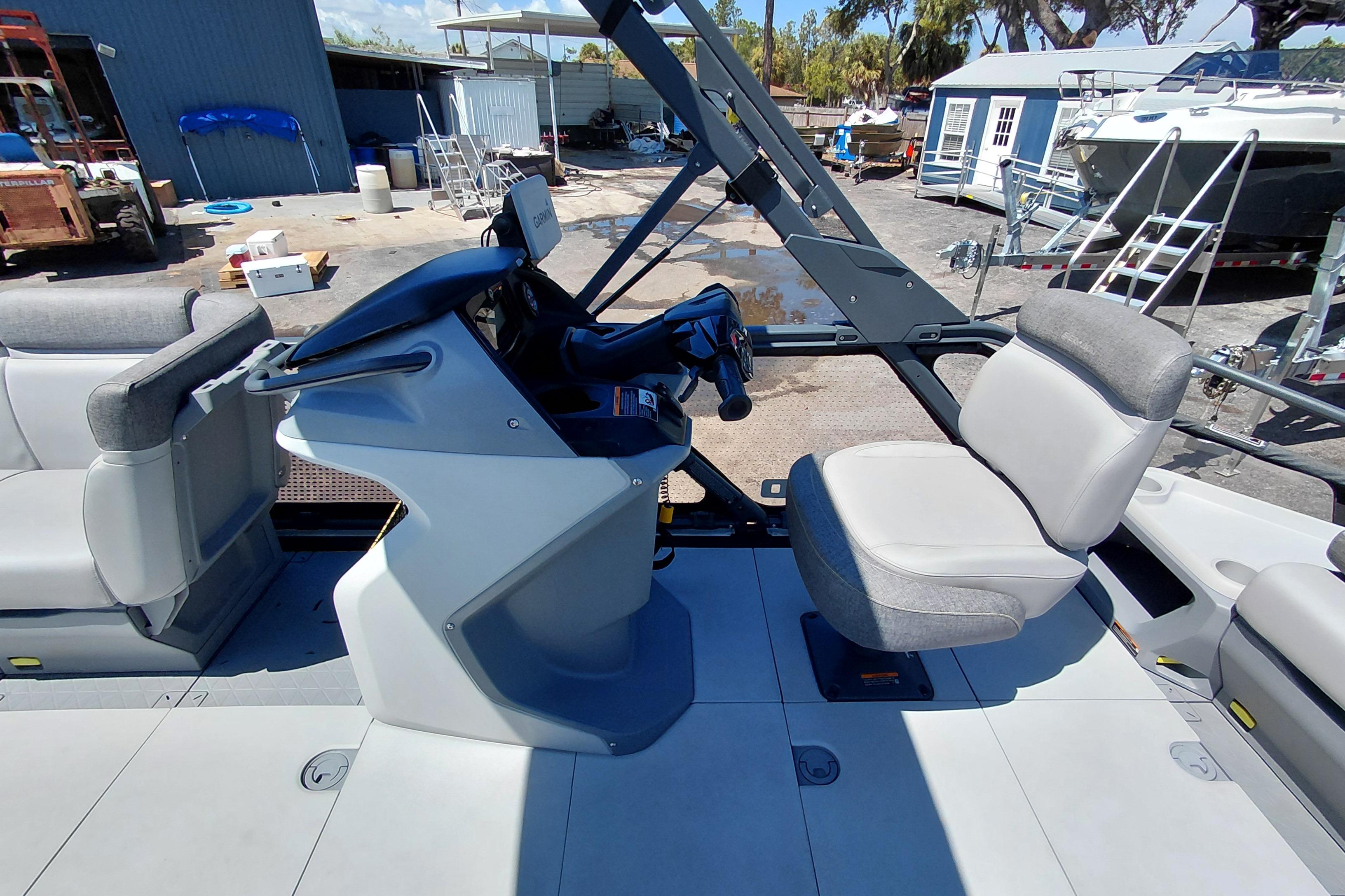 2024 Sea-Doo Switch Cruise 18 interior with steering console and seating in a marina setting.