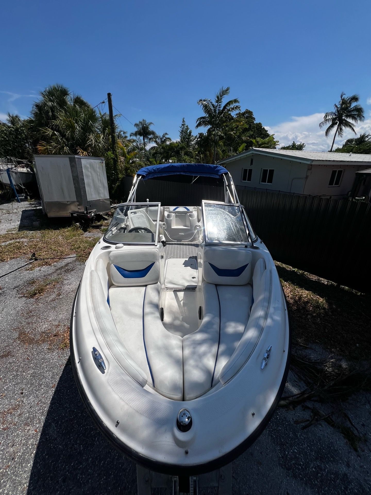 Bayliner 185 from 2006 on a dry lot with palm trees in the background.