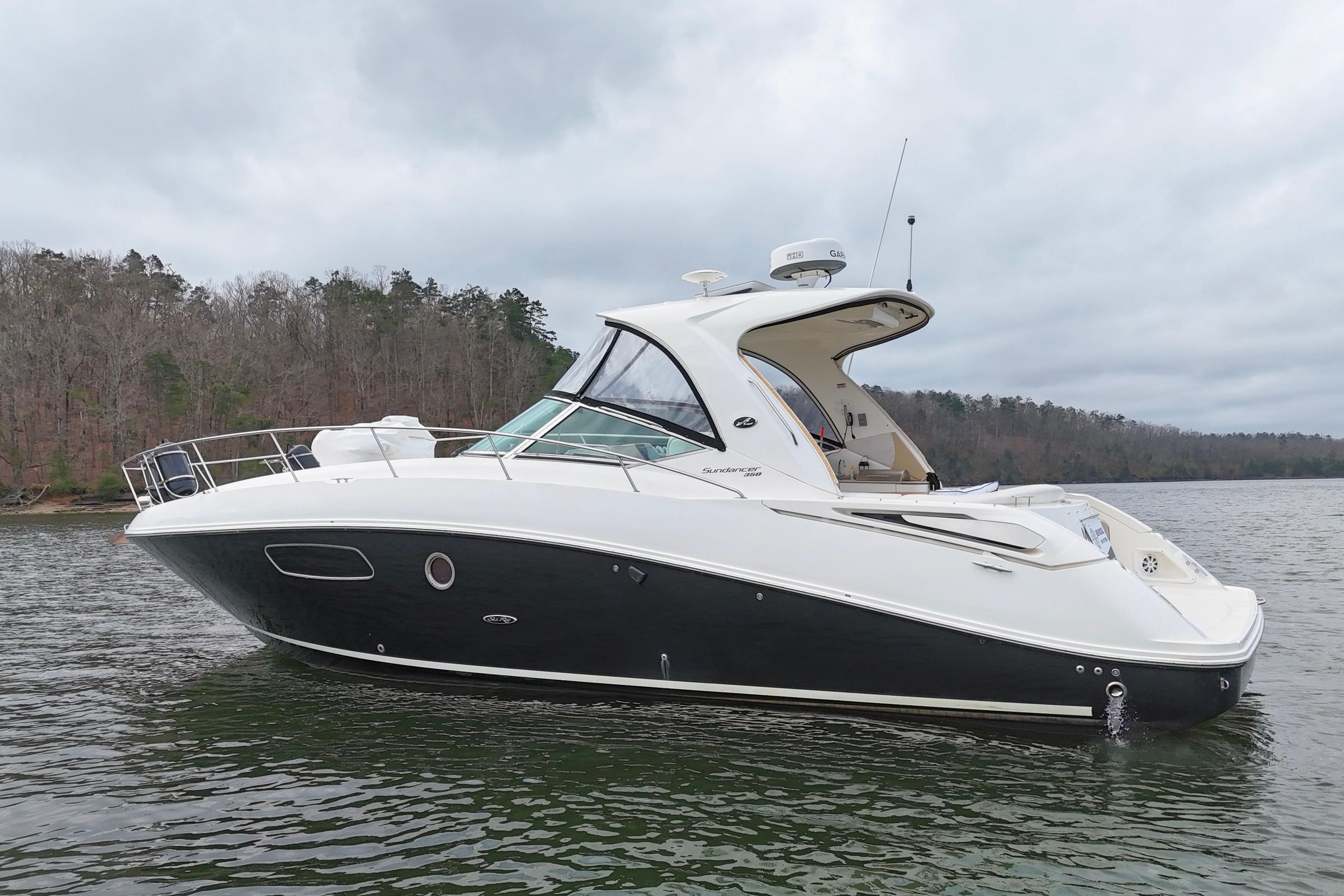 2009 Sea Ray Sundancer 350 yacht on a serene lake with wooded shoreline.