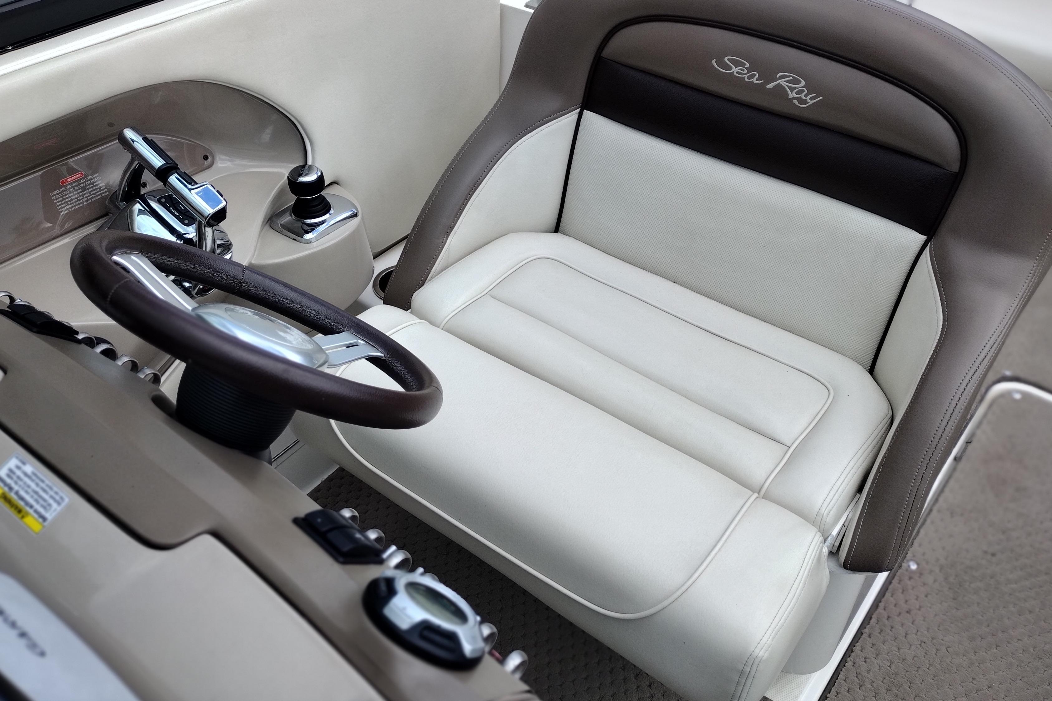 Captain's seat and controls of a 2013 Sea Ray 300 SLX boat.