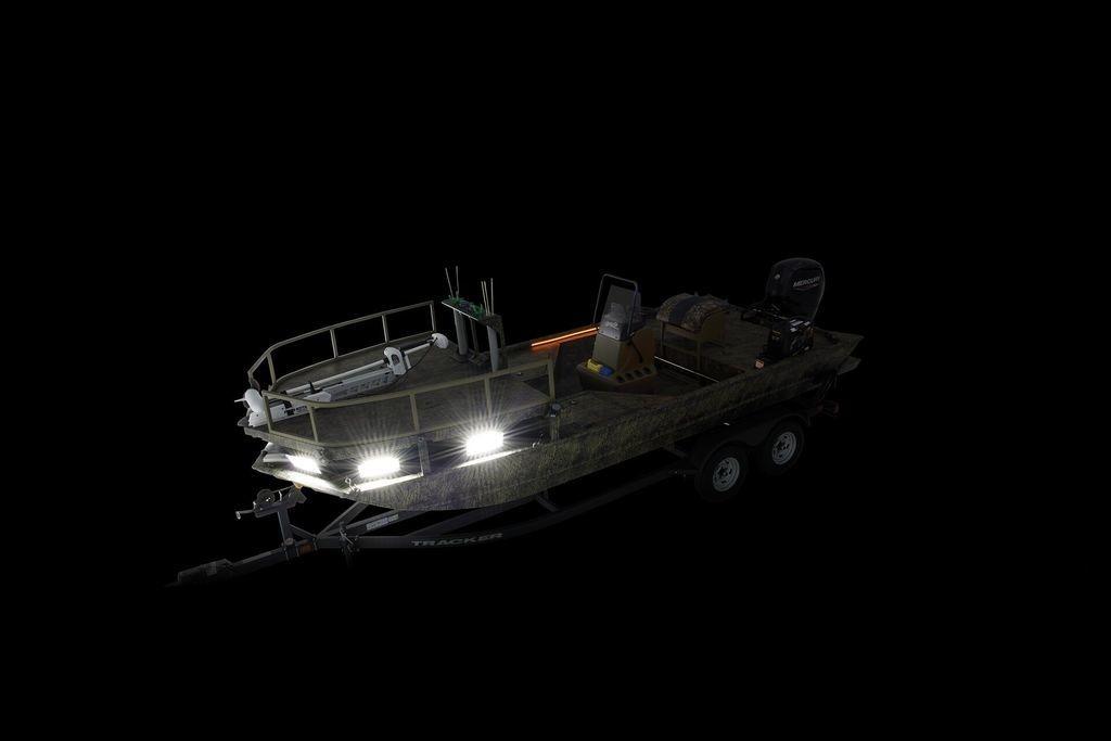 2026 Tracker GRIZZLY® 2072 CC Sportsman boat with trailer, illuminated in darkness.