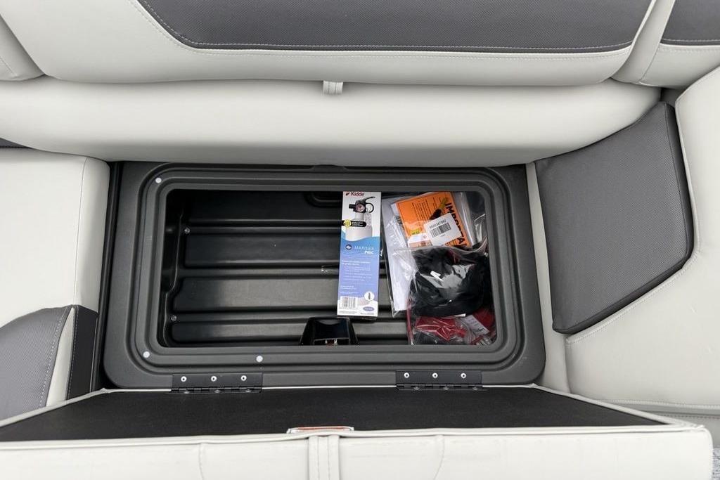 Storage compartment in 2026 Sun Tracker Fishin' Barge 20 DLX with fishing gear.