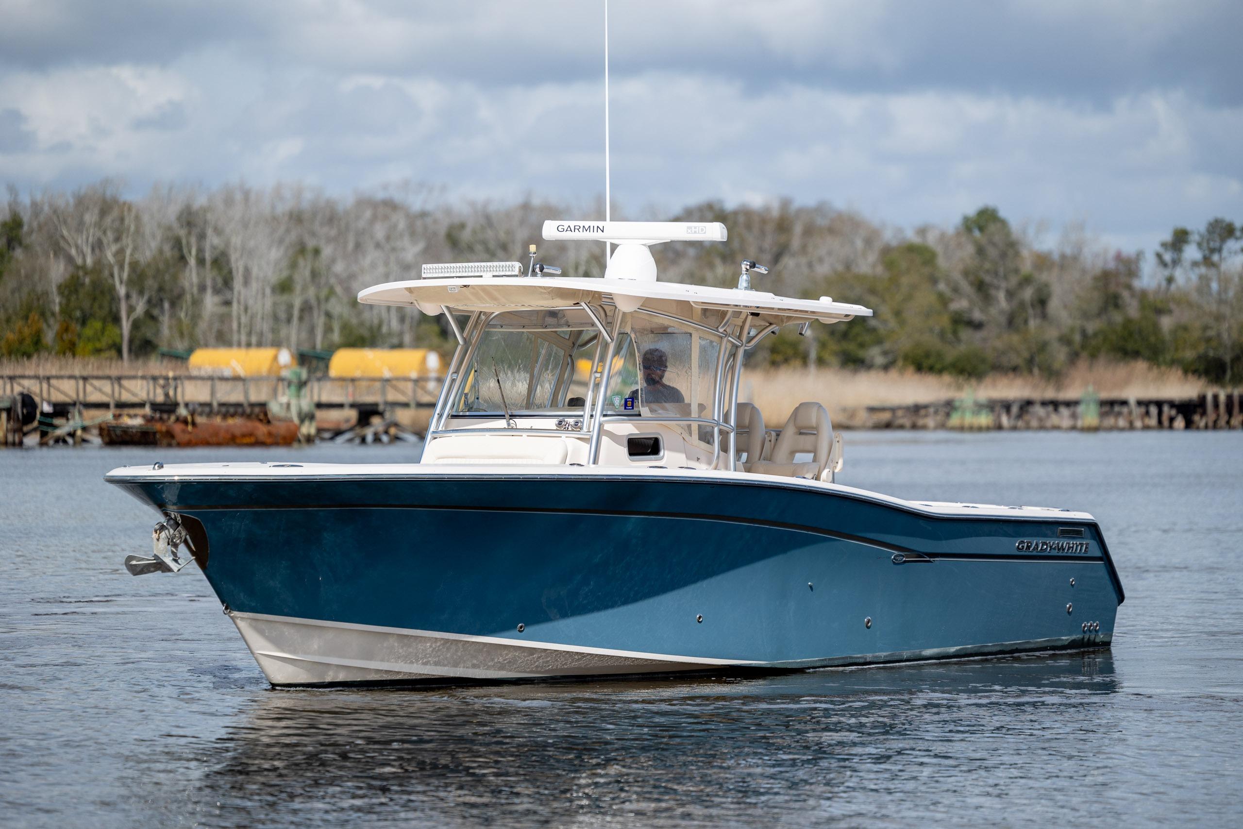 2013 Grady-White Canyon 306 boat on calm water, featuring a sleek blue hull.
