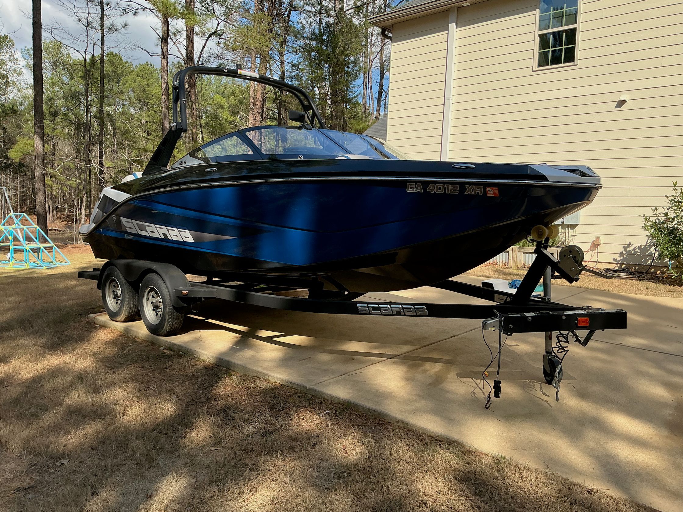 2021 Scarab 215 ID boat on trailer in driveway.