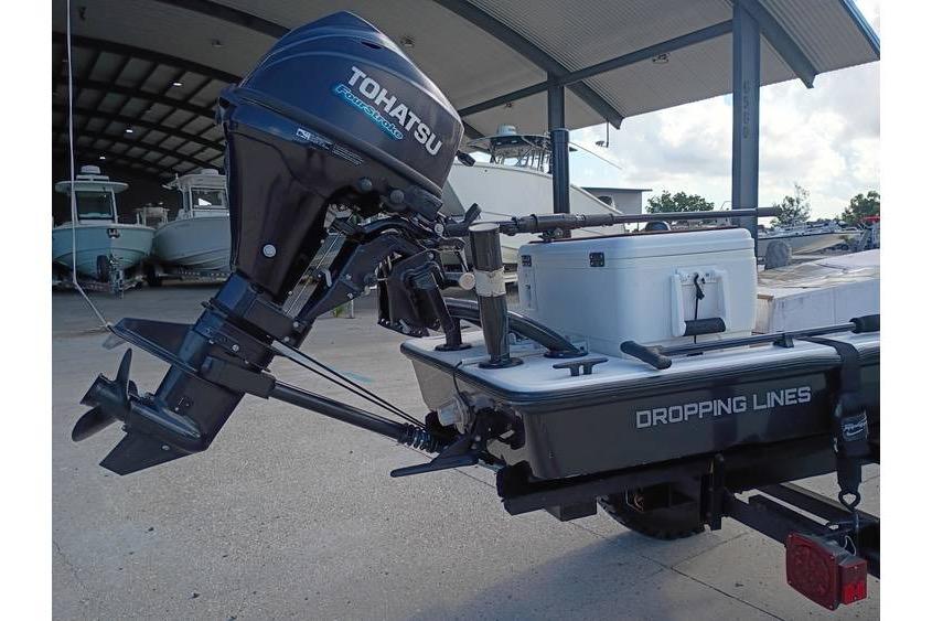 Pelican Ambush 2013 boat with Tohatsu outboard motor and fishing gear at a marina.