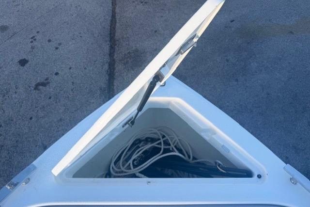 Open storage compartment on 2023 Cobalt R6 Surf boat, containing ropes.