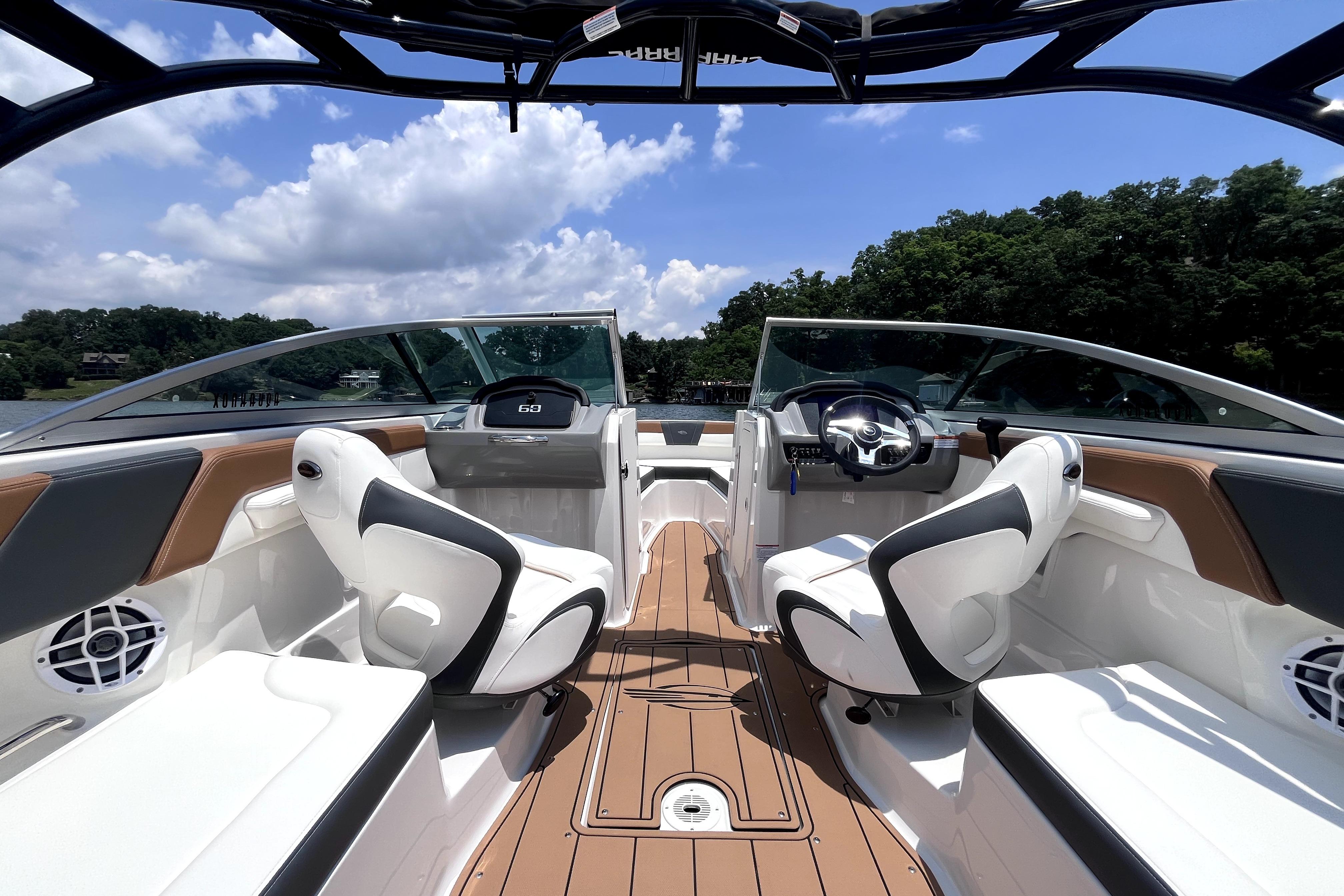 2025 Chaparral 230 SSi boat interior with sleek seating and modern dashboard on a sunny day.