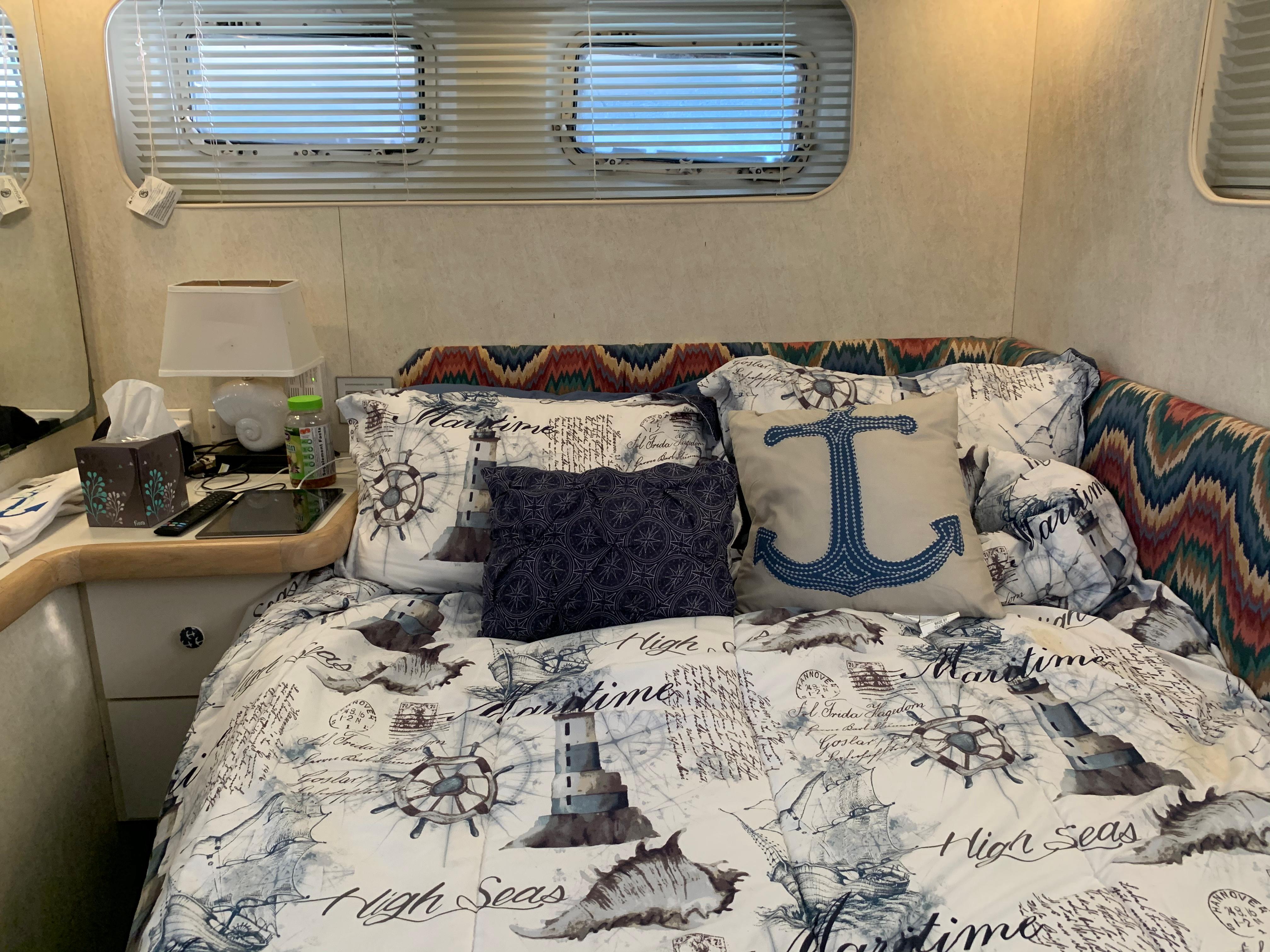 Cozy bedroom in 1992 Silverton 34 Aft Cabin Motor Yacht with nautical-themed bedding.