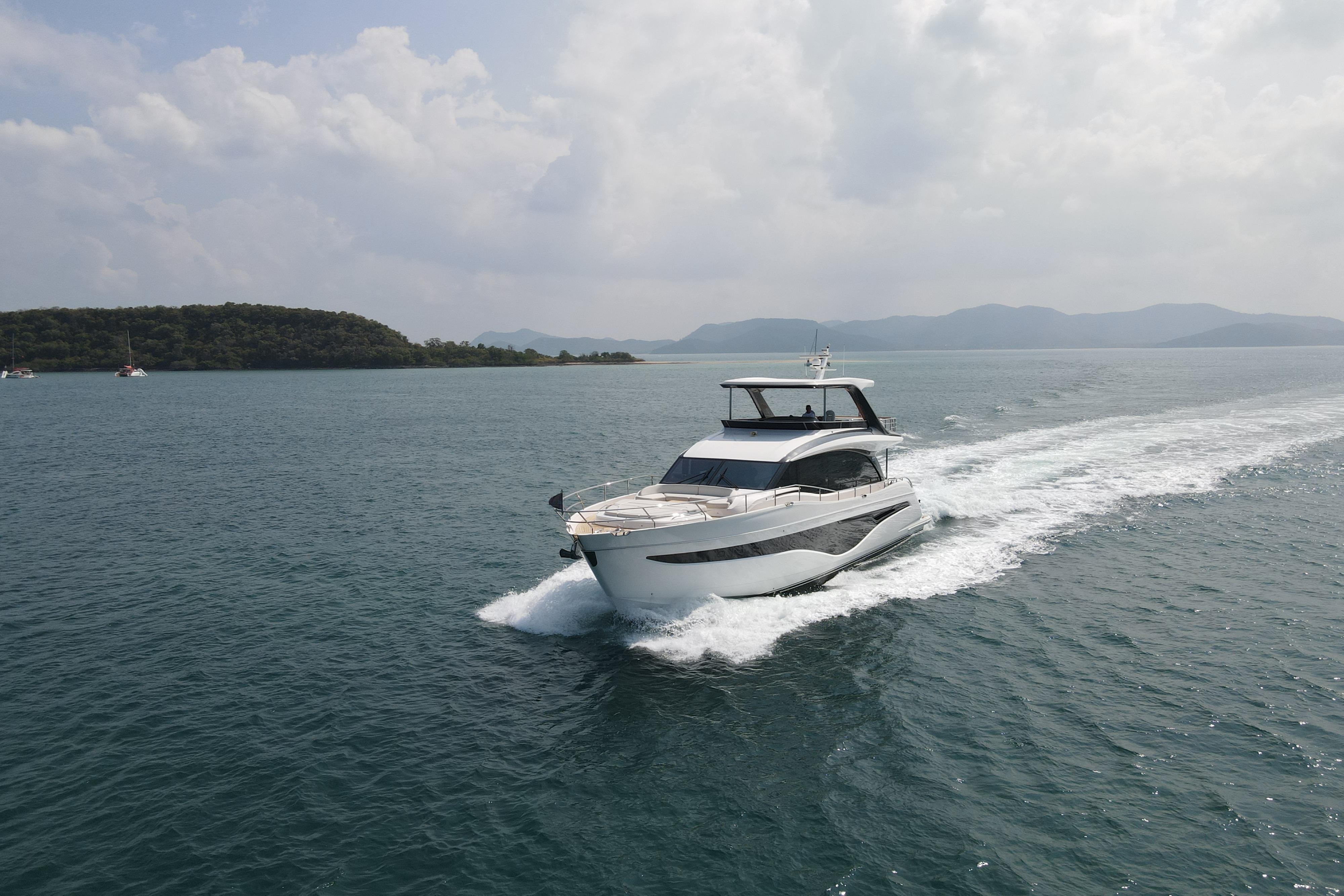 2023 Princess Y72 yacht cruising on open water with scenic island backdrop.