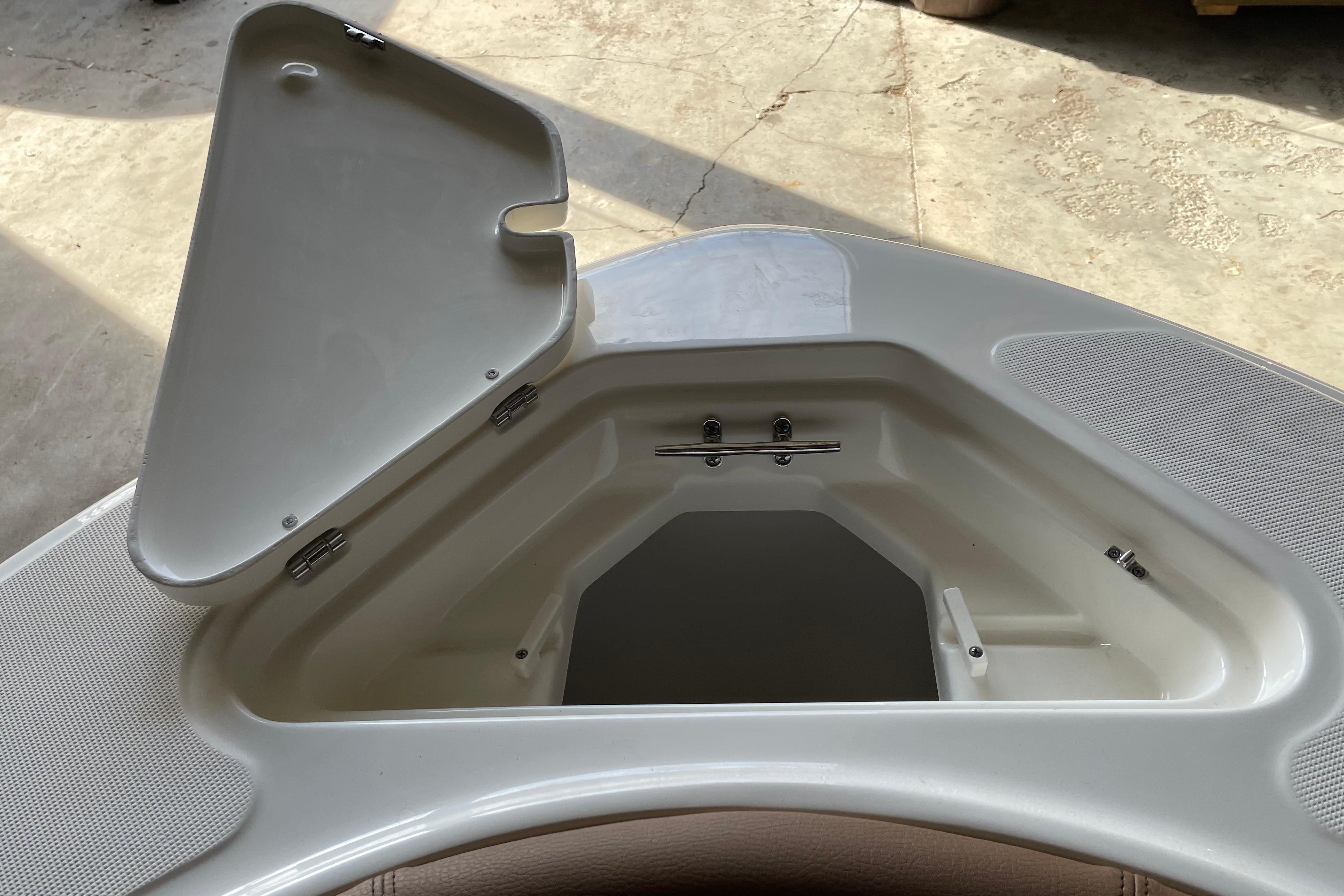 Open storage compartment on 2026 Pioneer 202 Islander boat, showcasing interior design.