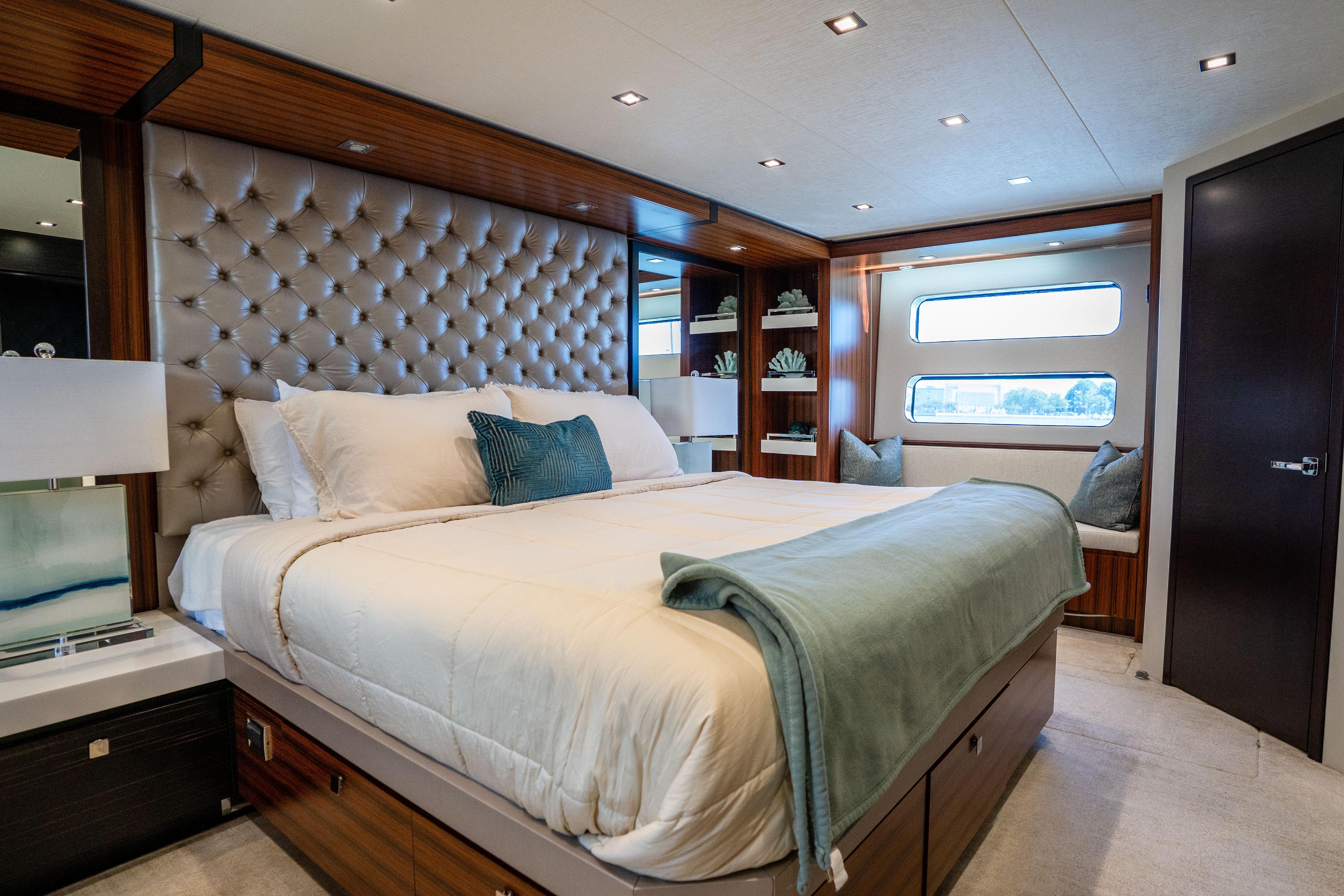 Luxurious bedroom interior of 2021 Hatteras M75 Panacera yacht with elegant decor and plush bedding.