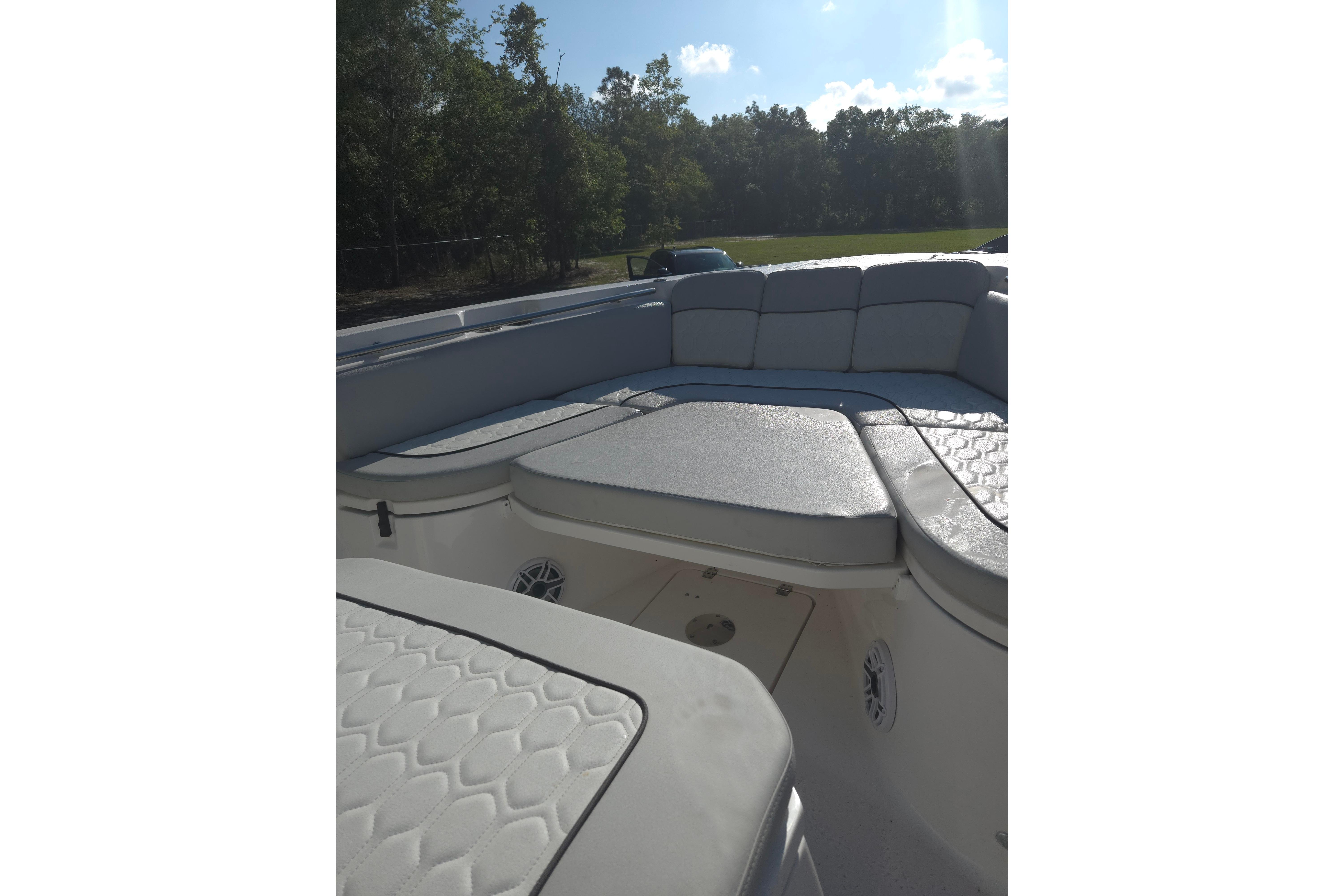 2023 Sea Fox 288 Commander boat interior with cushioned seating and sunny outdoor view.