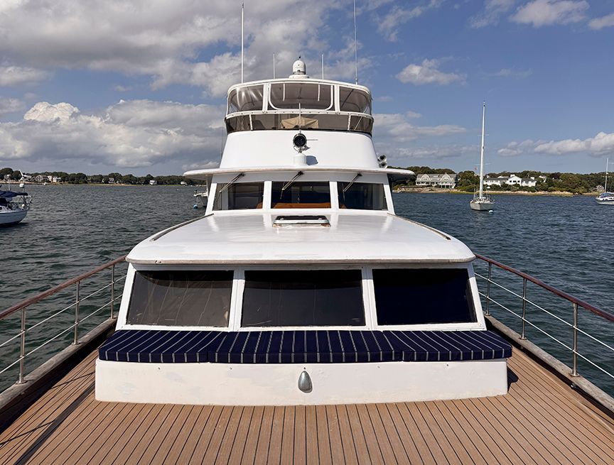 A 1961 Burger 63 on the water with blue skies and other boats in the background.