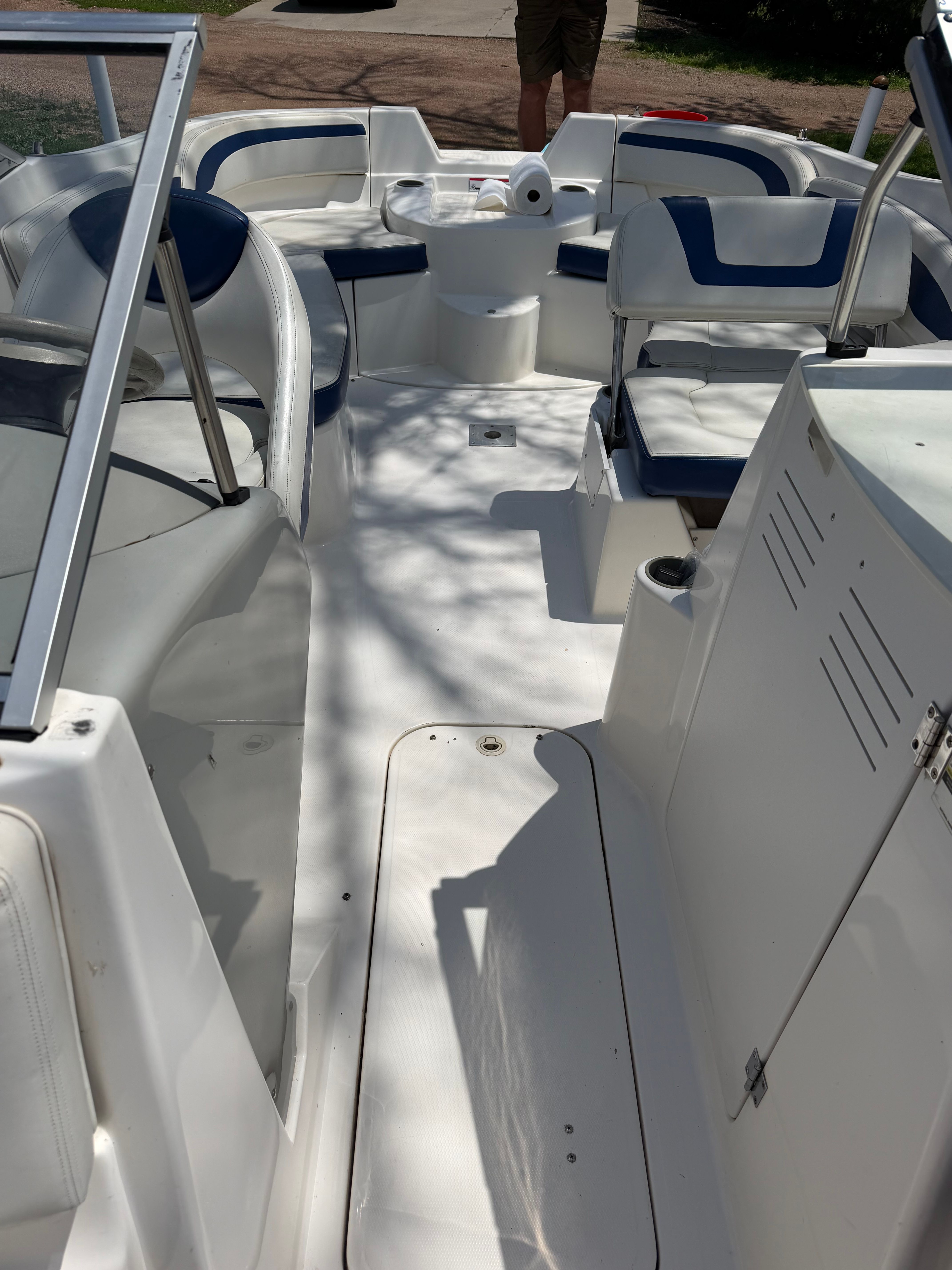 The image shows the open deck of a 2005 Bayliner 212 boat with blue and white seating.