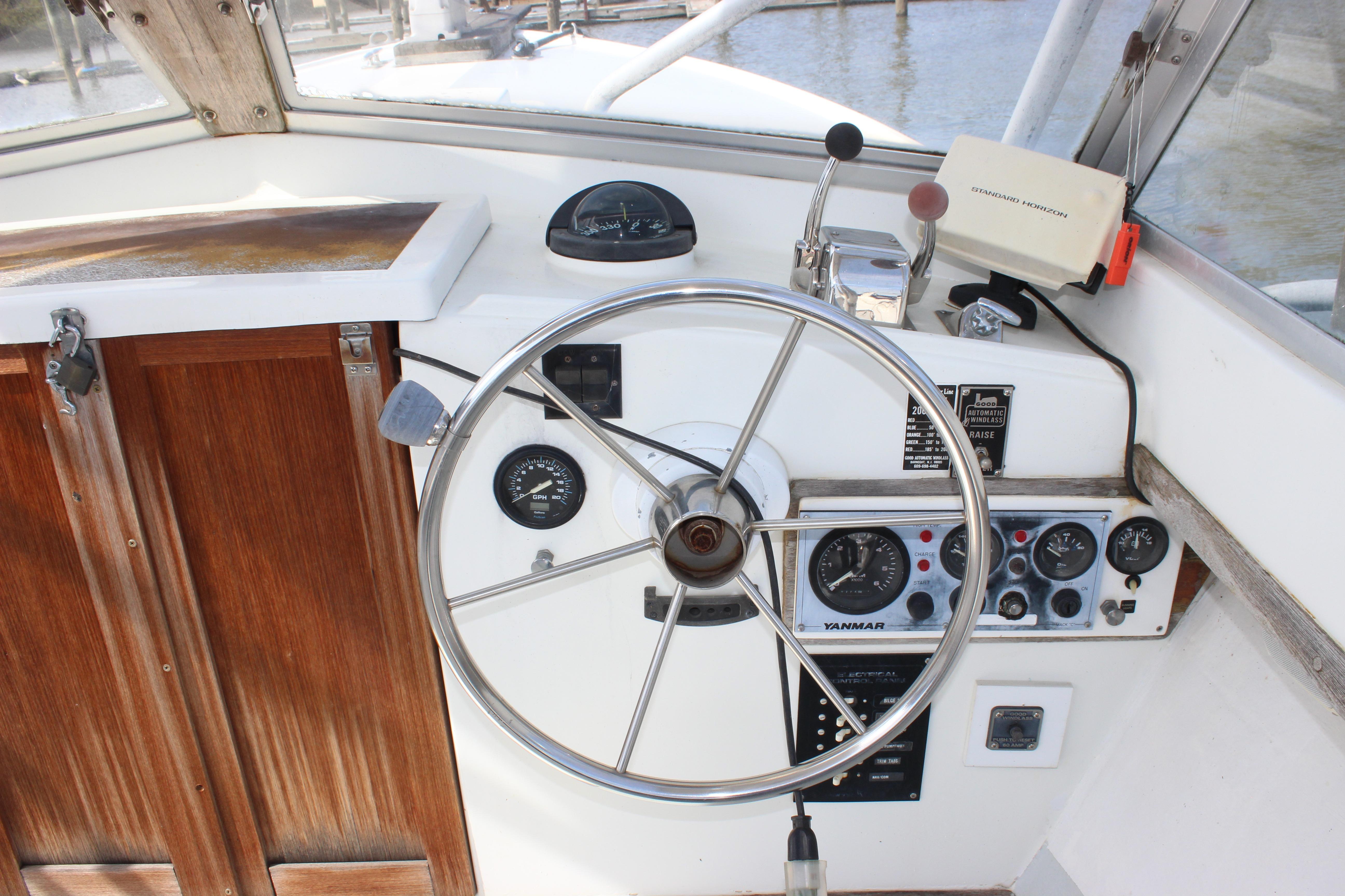 1979 Tripp Angler 22 Flush Deck Cuddy helm with steering wheel and control panel.